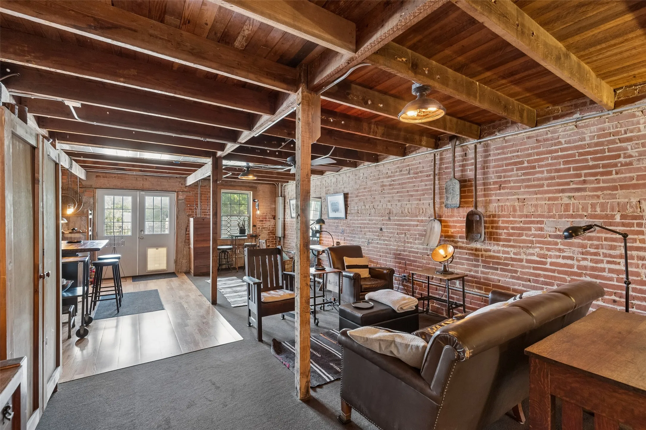 Exposed brick walls complement the wood-beamed ceiling and wood-finish flooring
