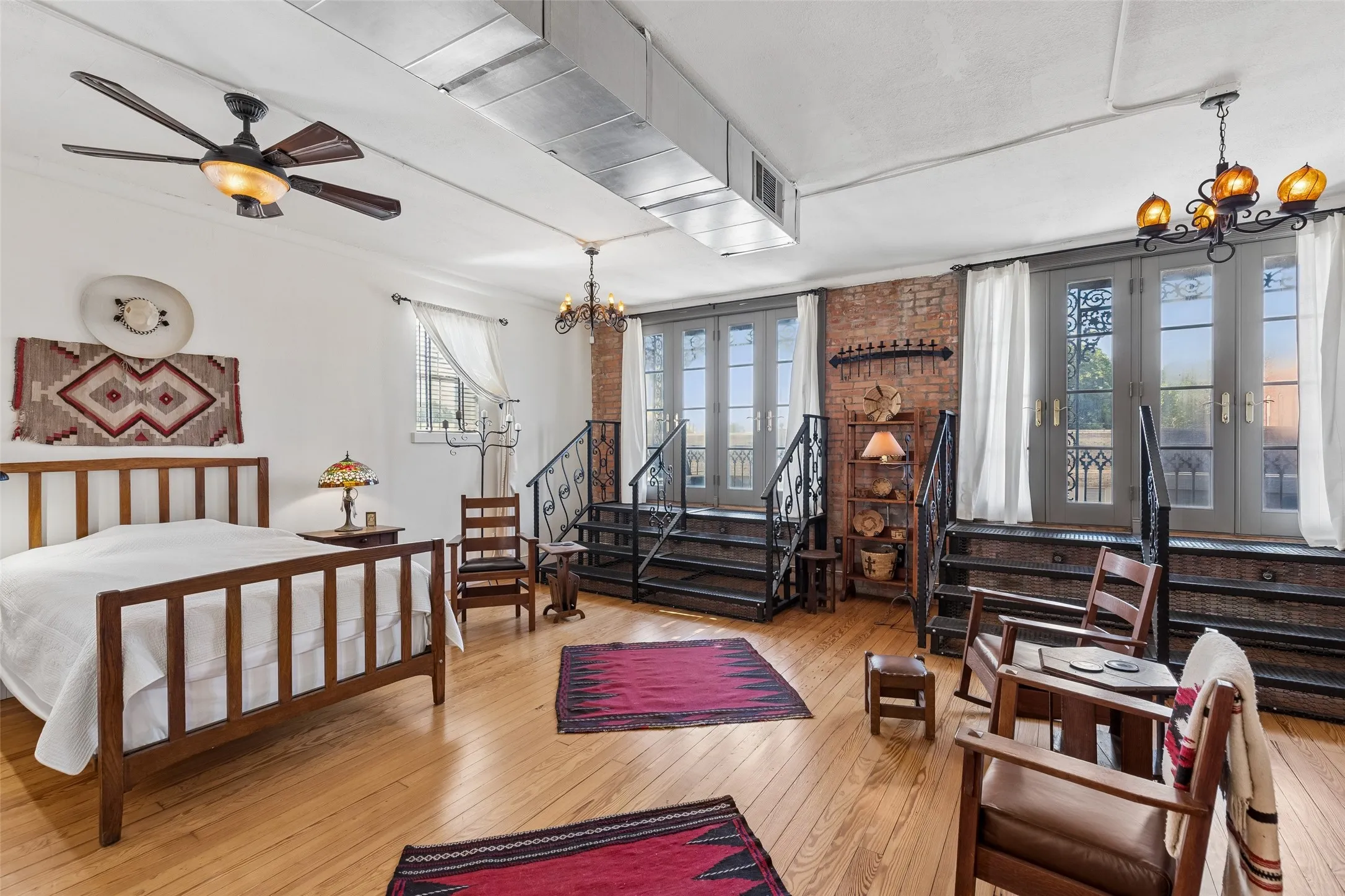 Hardwood flooring throughout featuring exposed brick accents and industrial-style ductwork