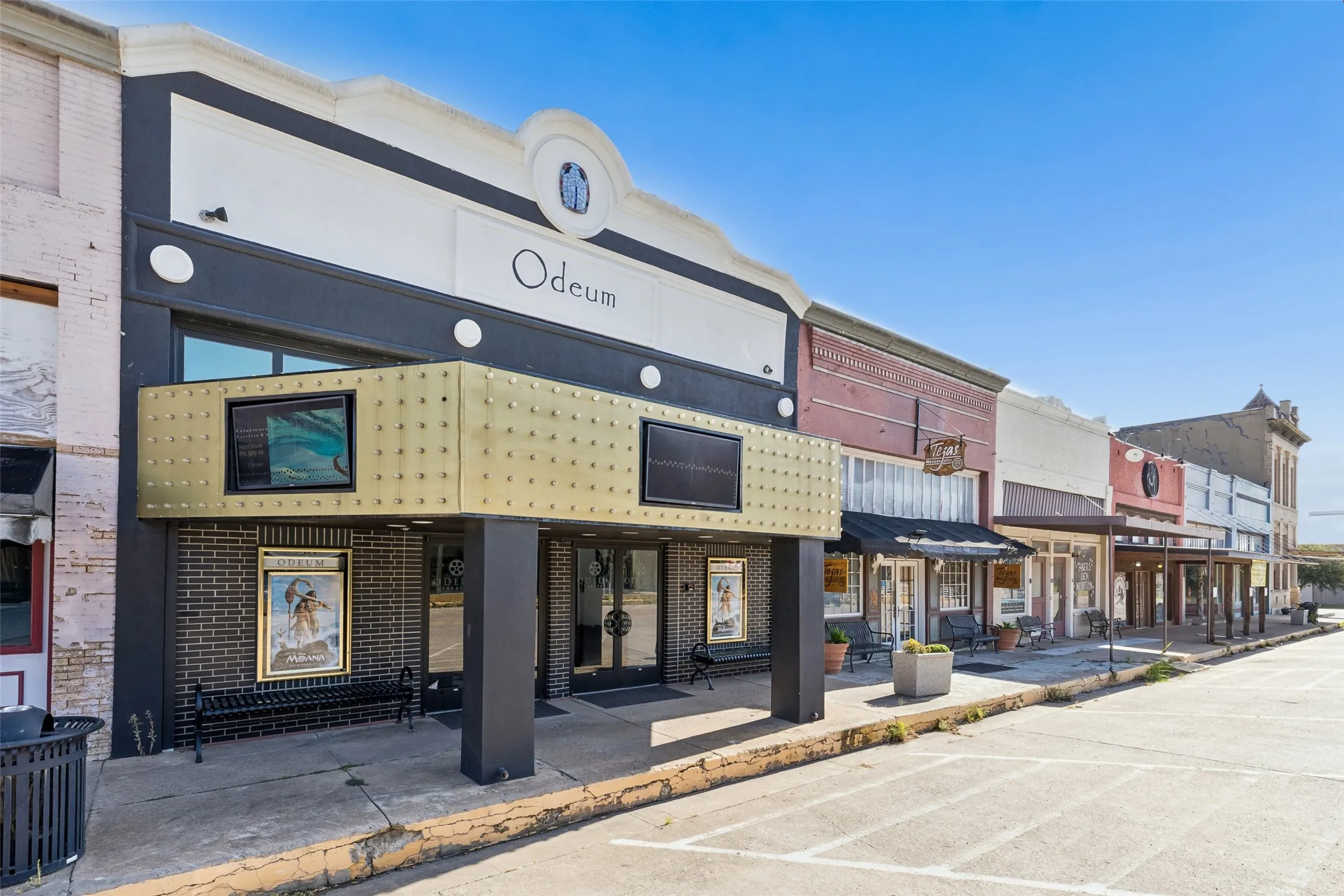 Commercial facade featuring a black and white upper section with "Odeum" signage
