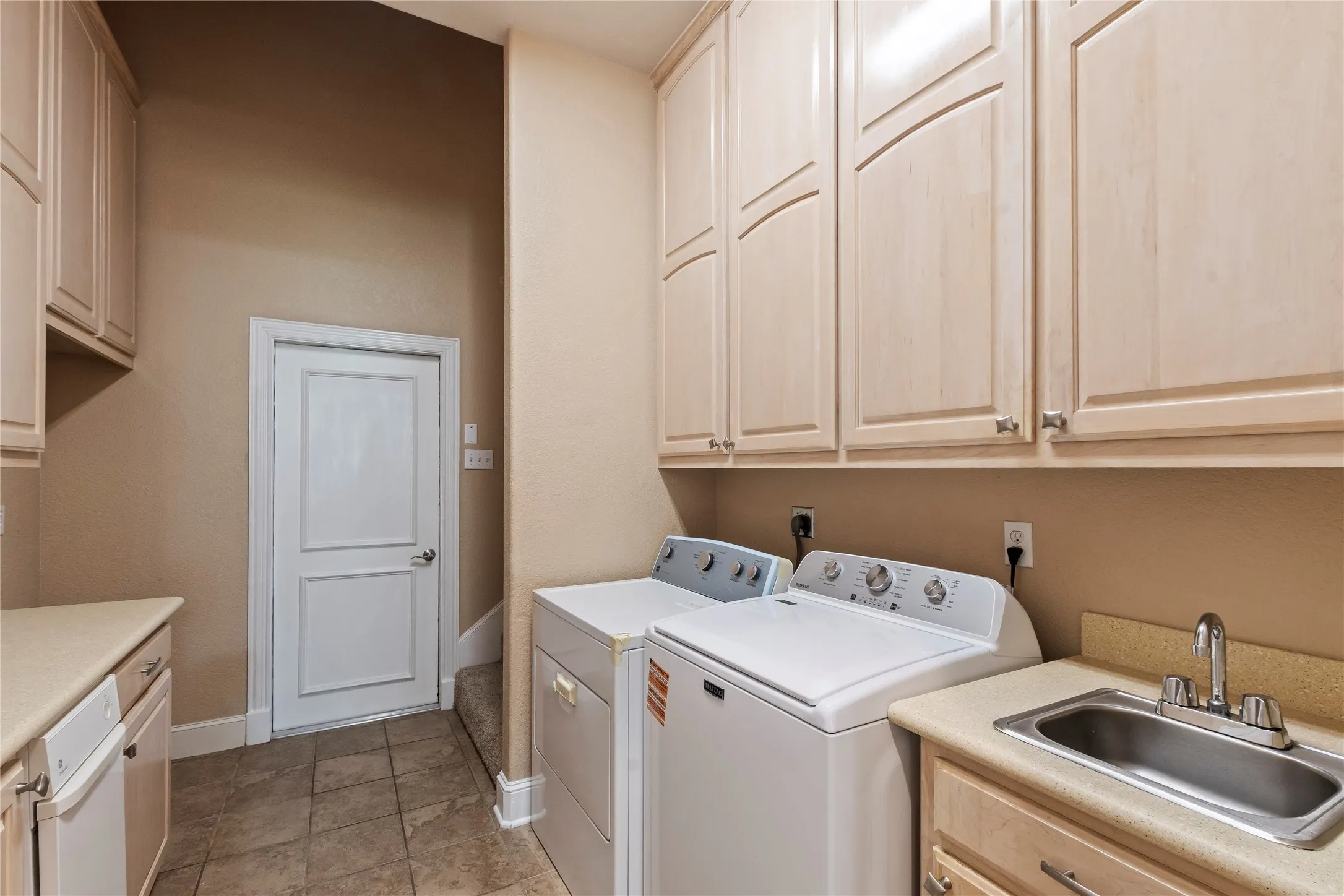 Laundry room with utility sink, access garage