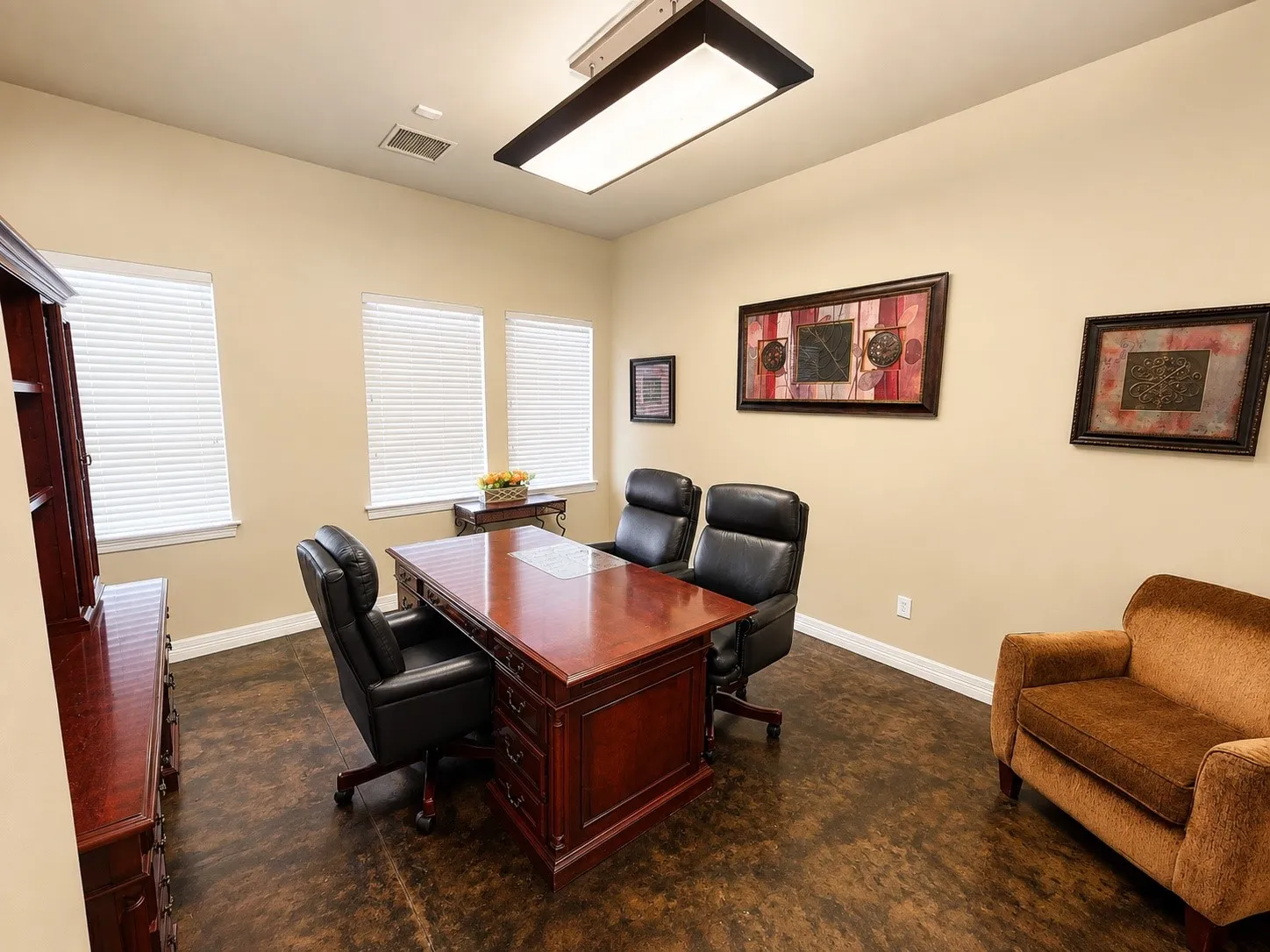 Room featuring textured flooring, light-toned walls, and multiple windows with horizontal blinds