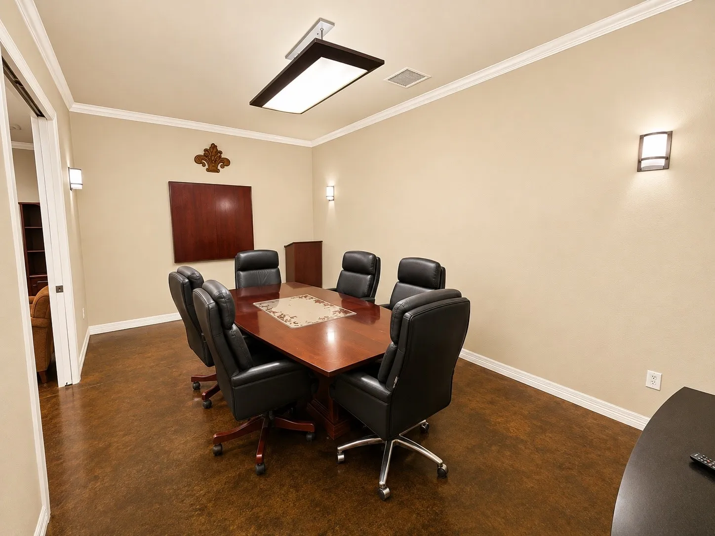 Formal meeting room featuring crown molding, recessed ceiling lighting, wall-mounted sconces, and wood-finish flooring