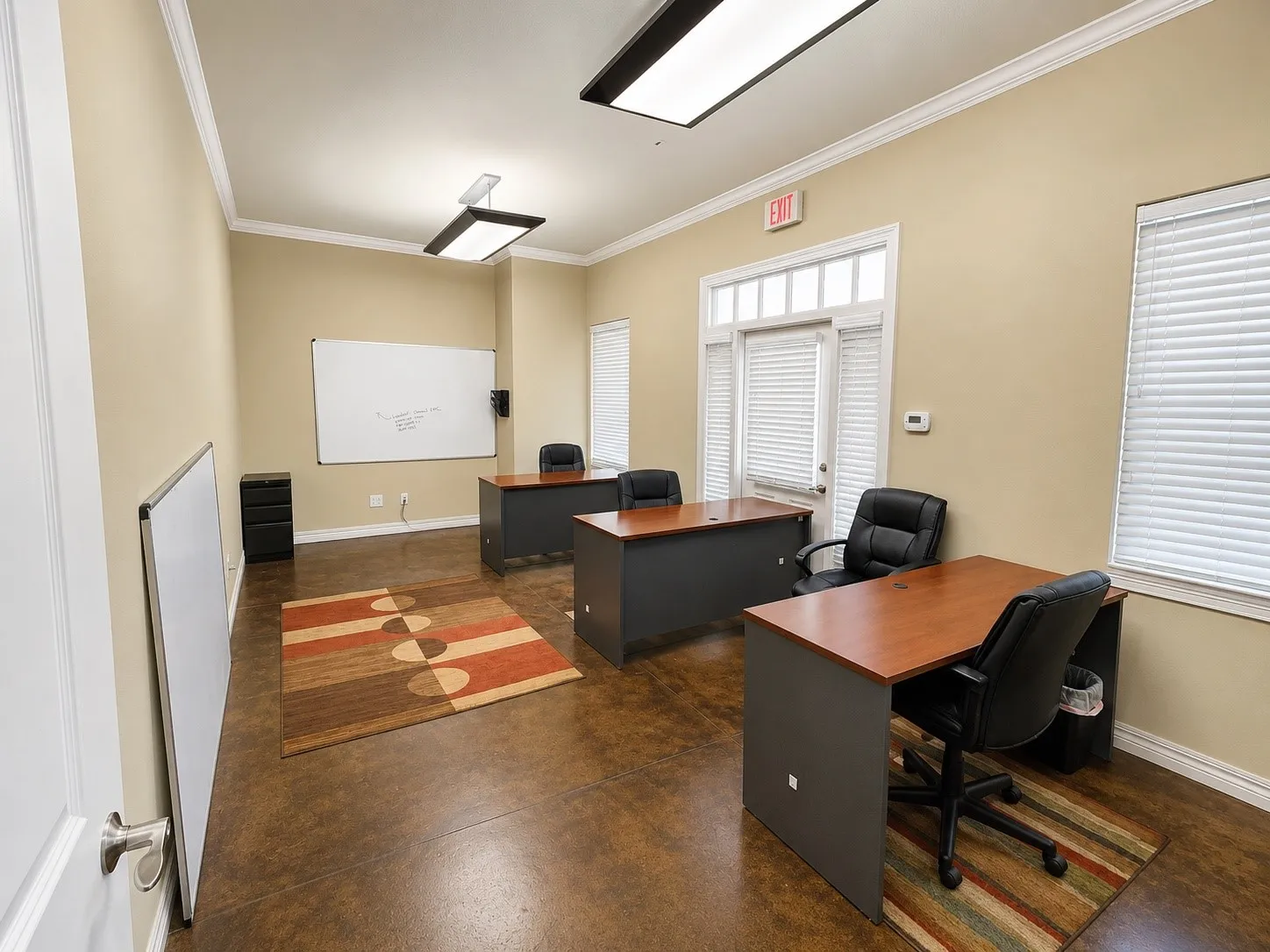 Spacious room featuring durable concrete flooring, crown molding, and neutral wall tones