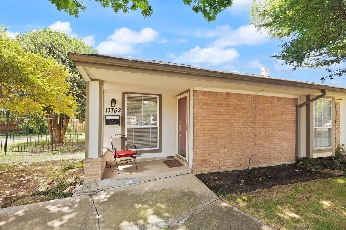 Brick and siding exterior with a red front door, covered entry, and a prominent front window with blinds