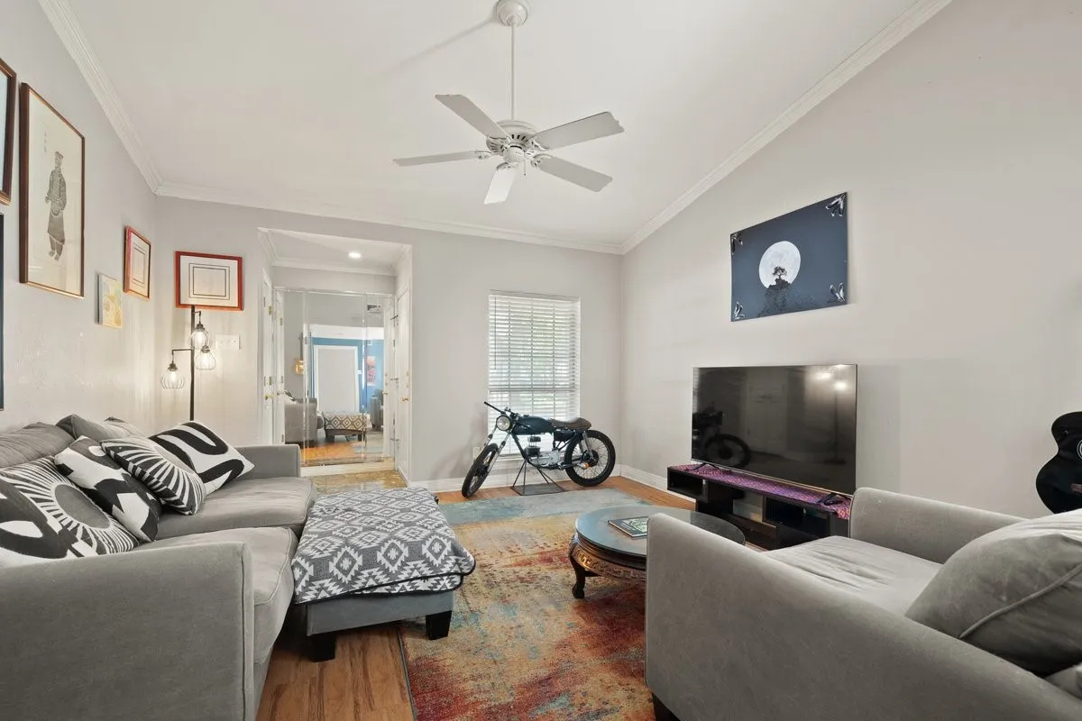 Vaulted ceiling with crown molding and ceiling fan
