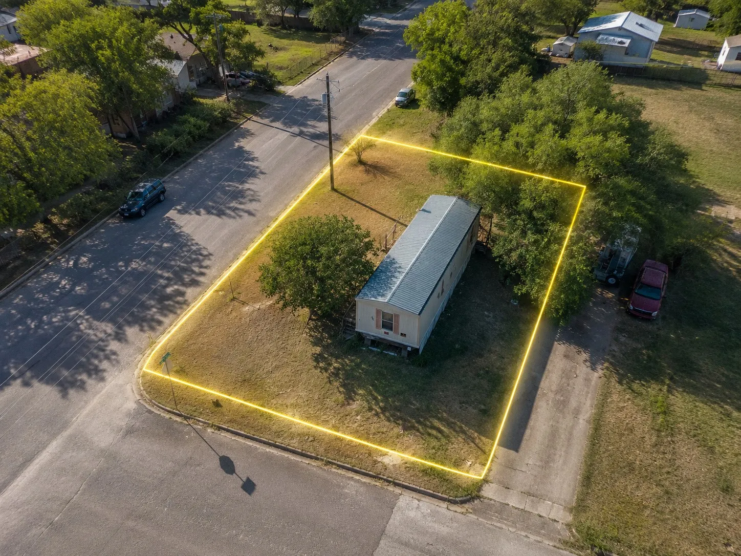 Bright, wide aerial perspective showing the home's placement on the lot and road frontage.