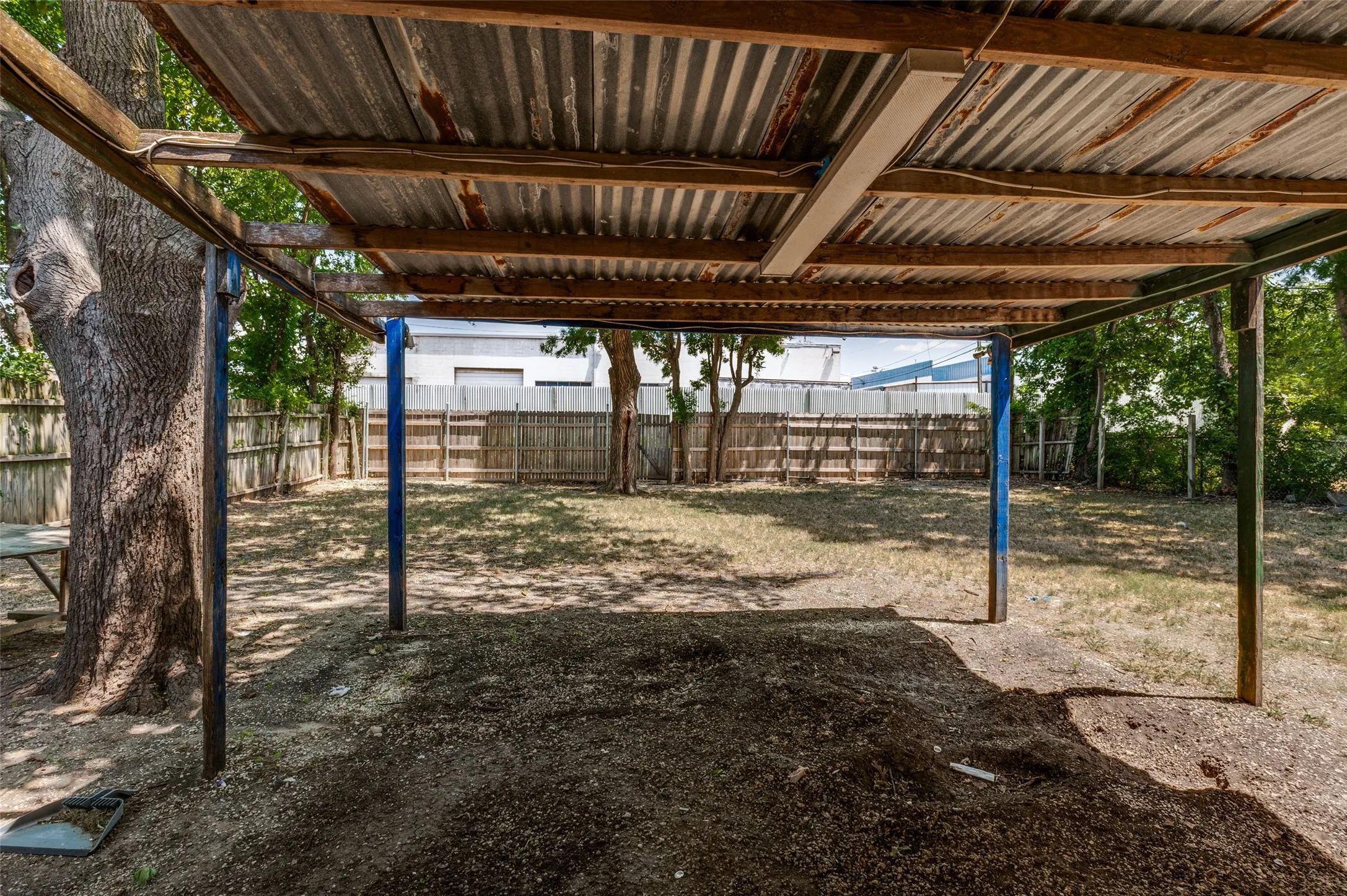 Covered patio area featuring a corrugated metal roof and exposed wood beams