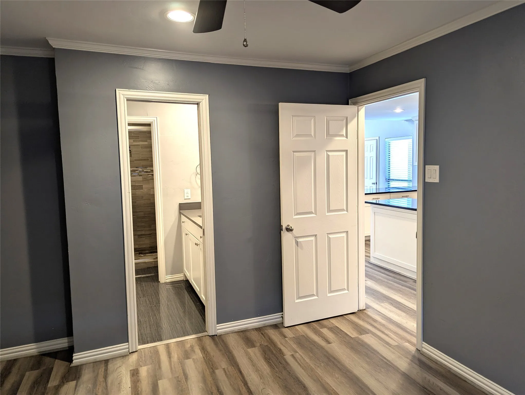Wood-finish flooring throughout, crown molding, and recessed lighting