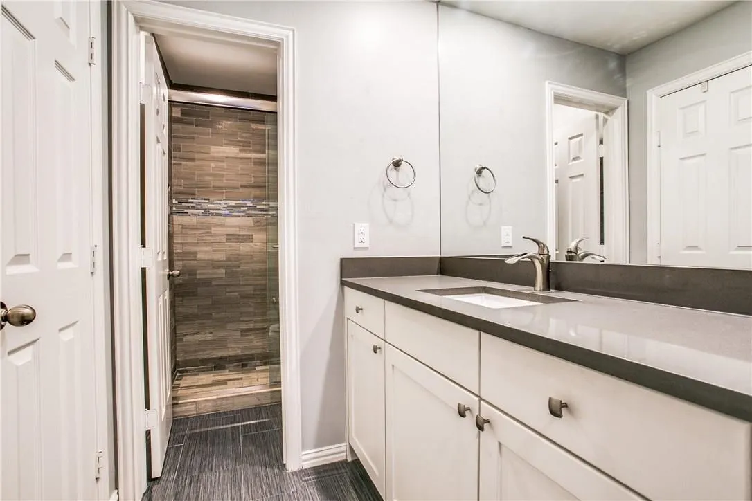 Bathroom vanity with a gray countertop, an undermount sink, and a large wall-mounted mirror