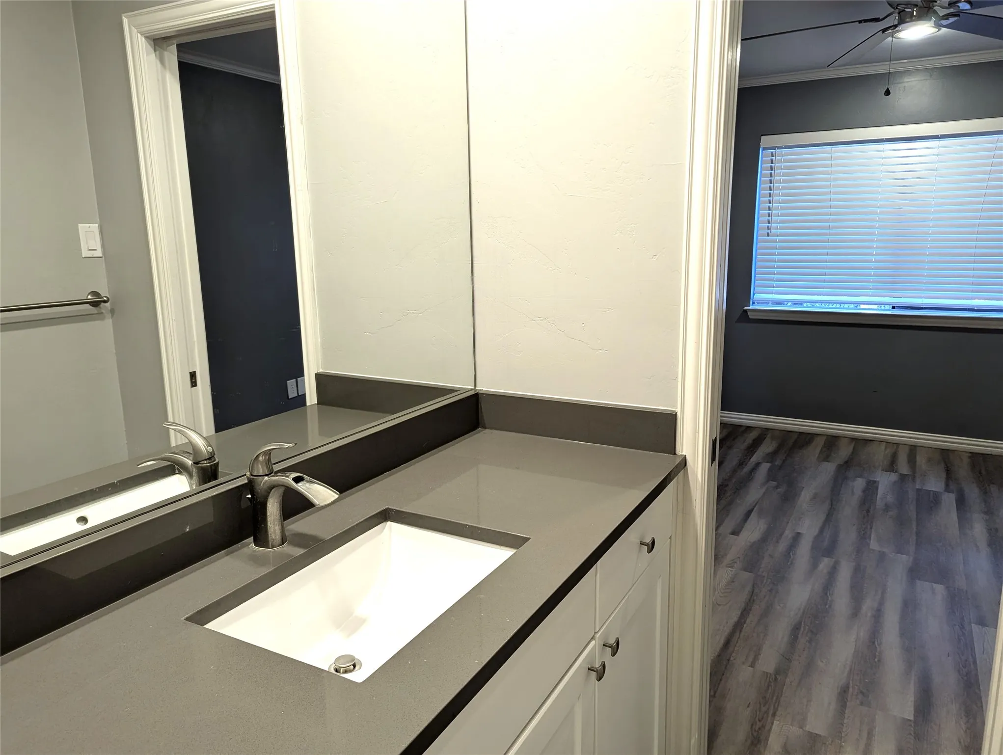 Vanity with integrated sink, solid surface countertop, and brushed nickel faucet