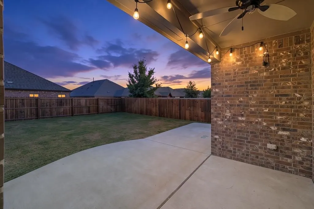 Covered patio with outdoor ceiling fan. Fully extended patio & evening view of backyard.