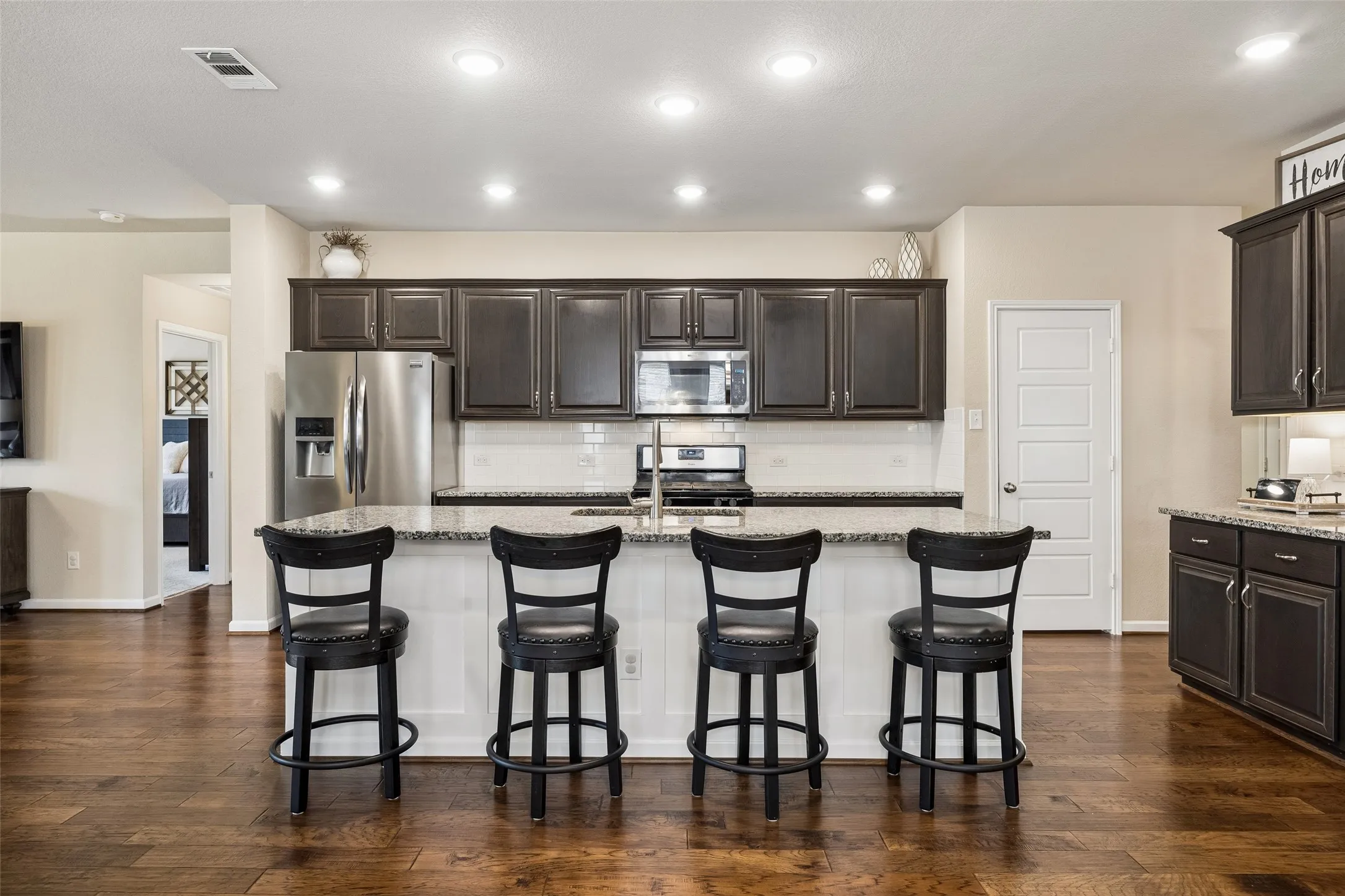 The oversized island has breakfast bar seating and a sink.