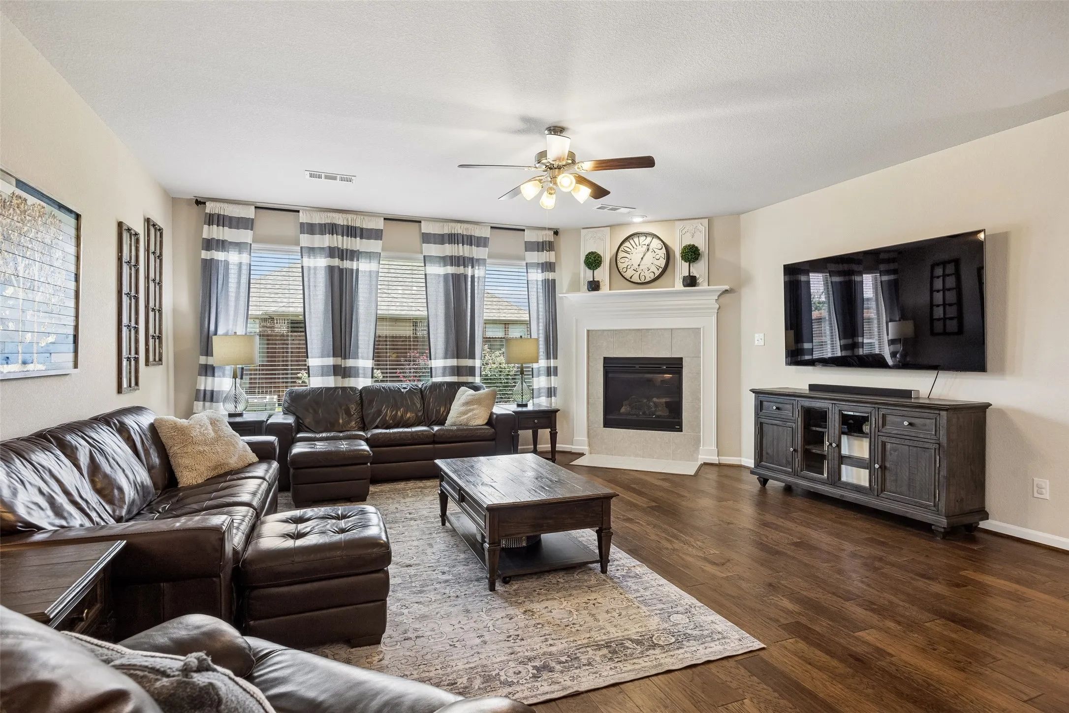Spacious living area featuring a ceiling fan and fireplace