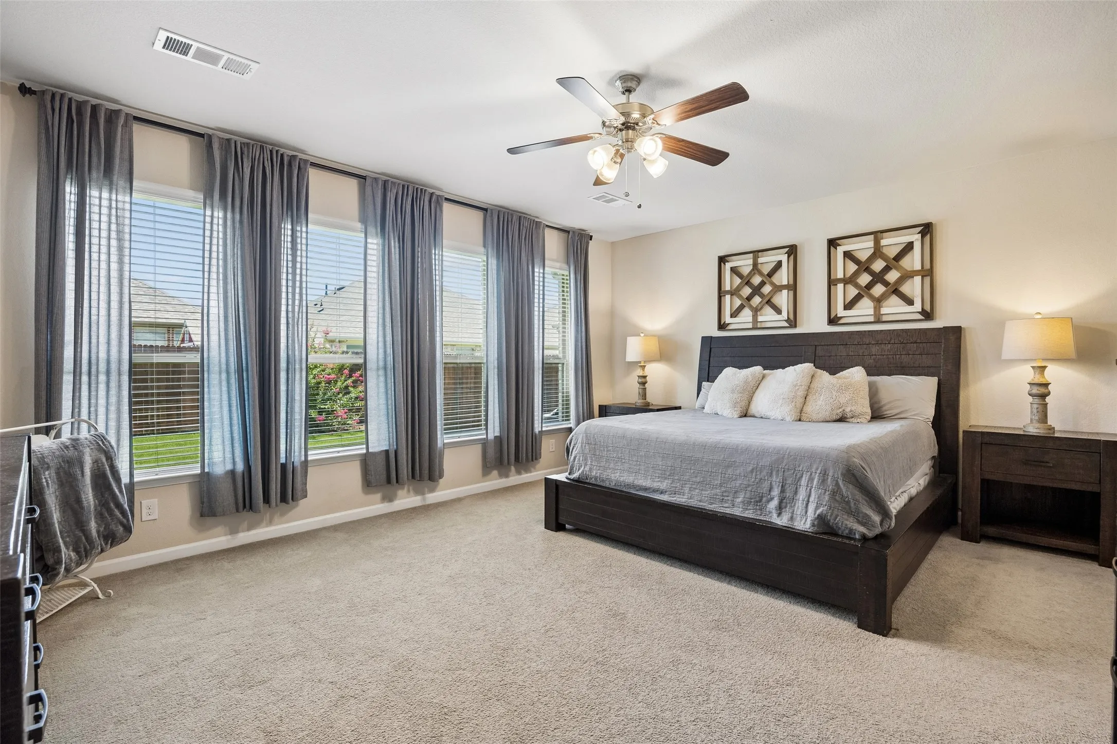 Primary bedroom featuring multiple windows with views of the backyard