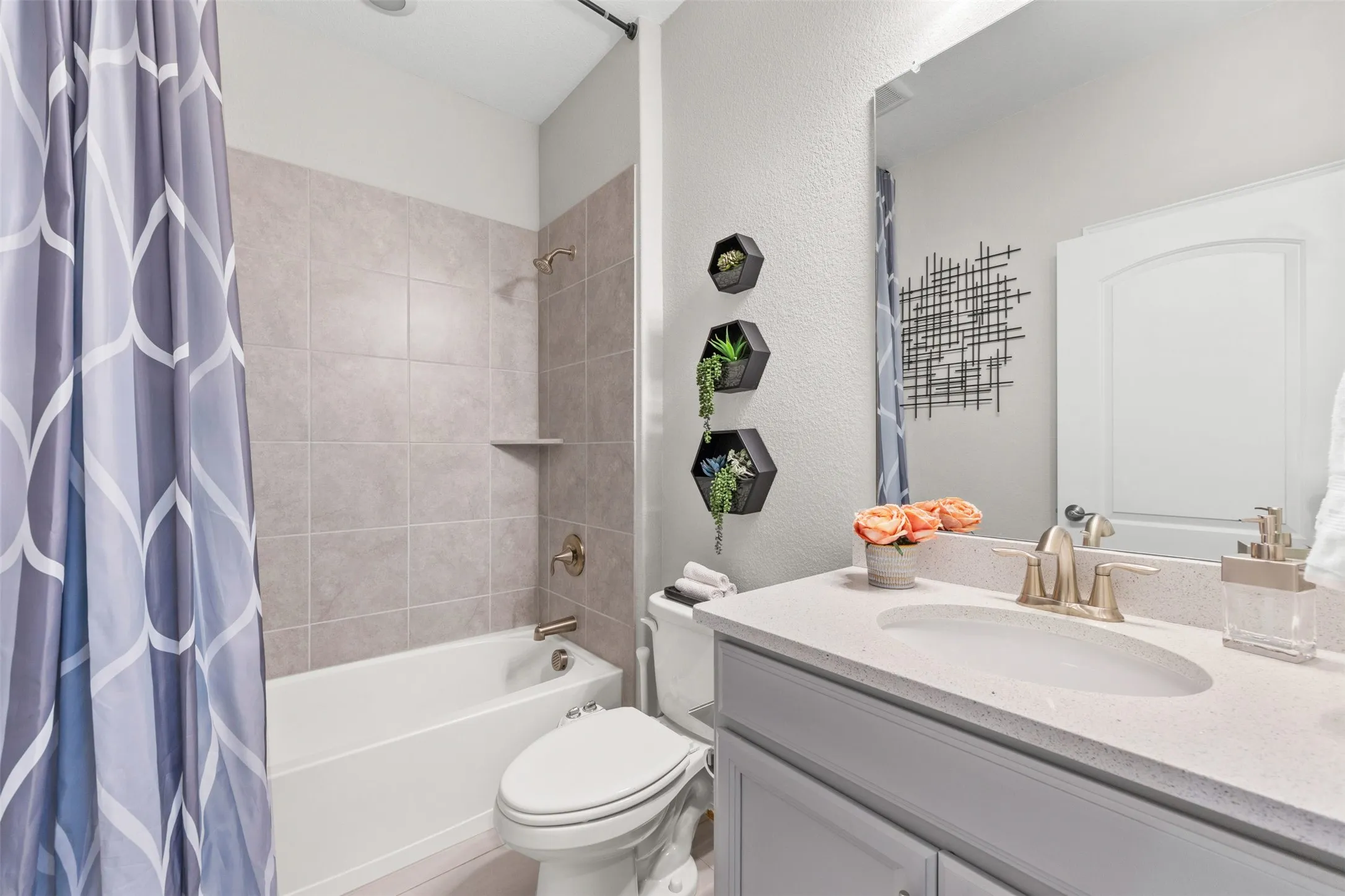 Bathroom featuring a built-in tub with tile surround, a single vanity with an integrated sink, and an arched panel door