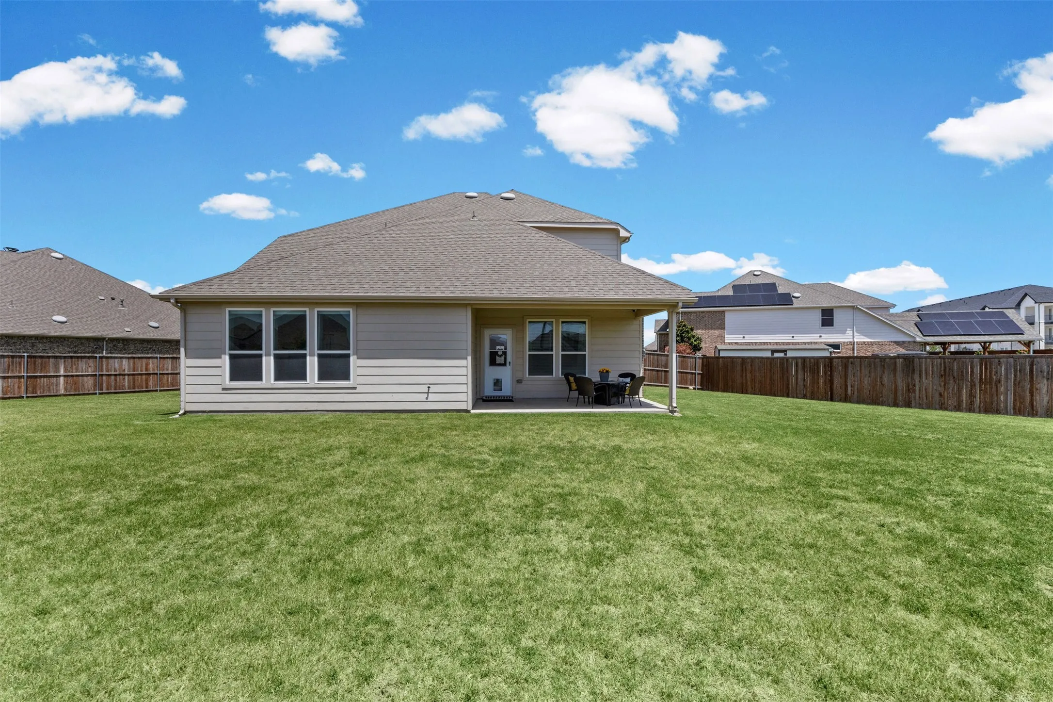 Expansive green lawn bordering a wood privacy fence