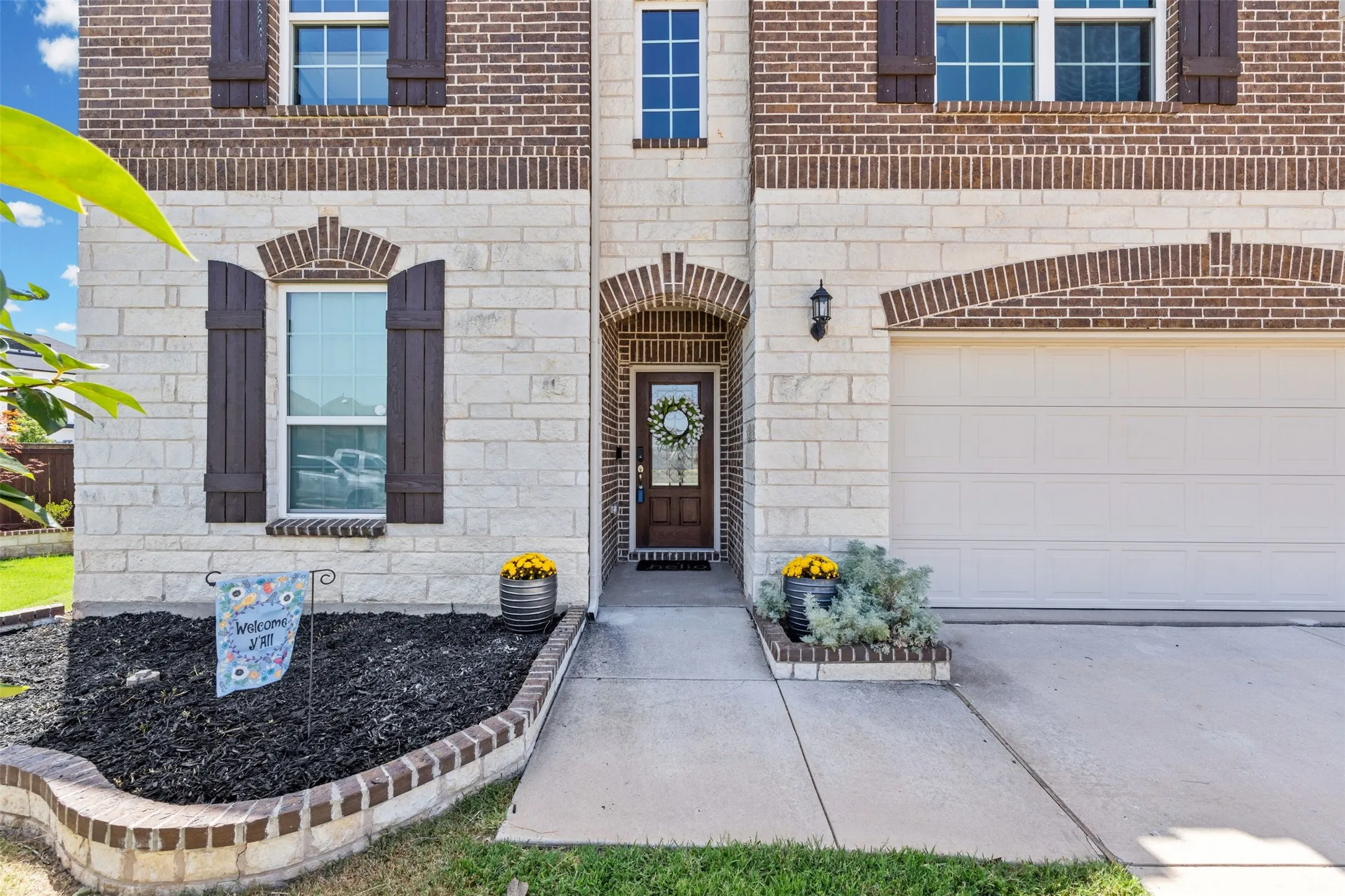 Two-story stone and brick facade with arched window and door accents