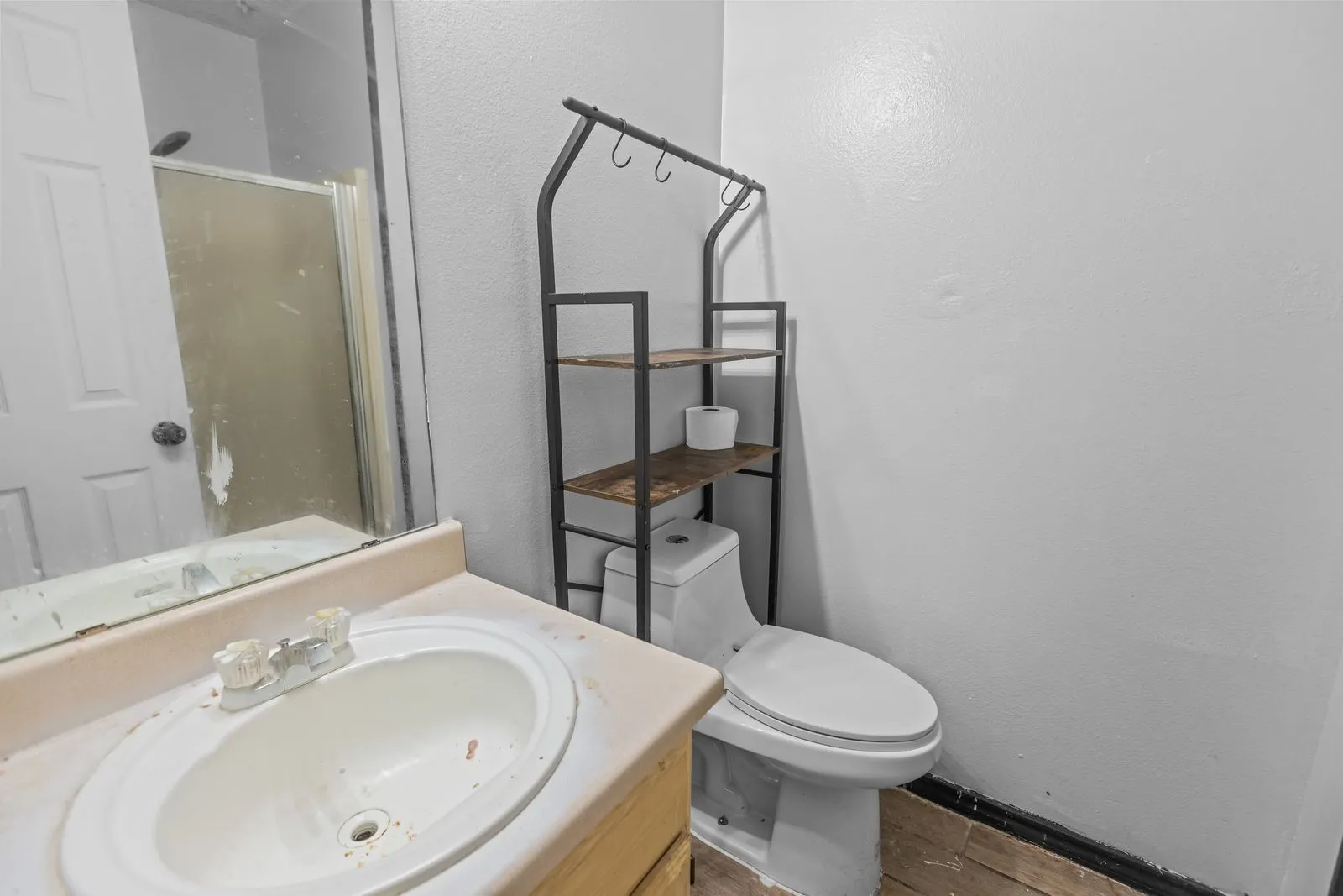 Vanity with an integrated sink and a wall-mounted mirror