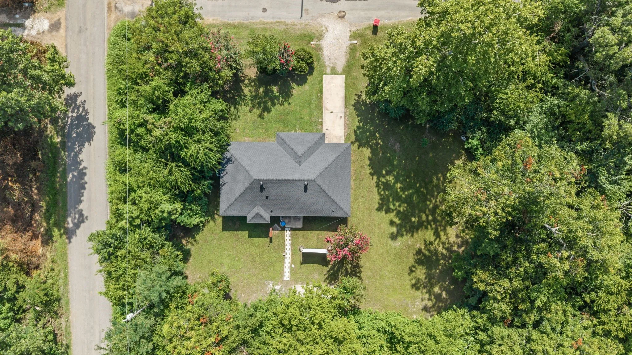 Single-story residence featuring a dark shingle roof and a concrete driveway