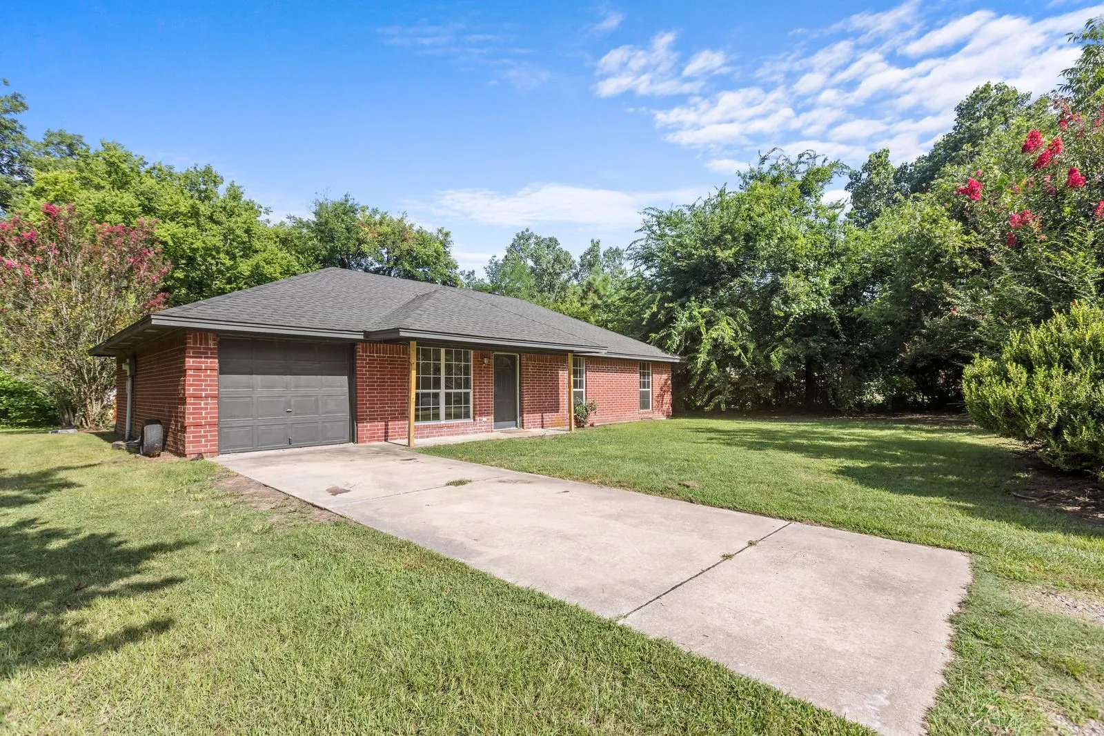 Brick exterior residence featuring an attached garage and a concrete driveway