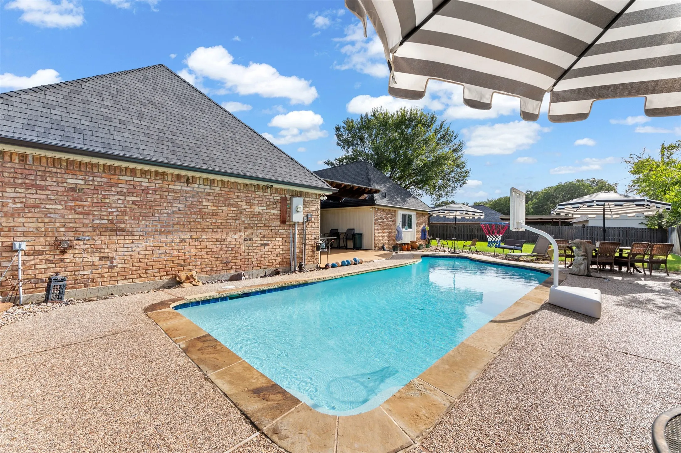 Outdoor pool with surrounding exposed aggregate concrete patio