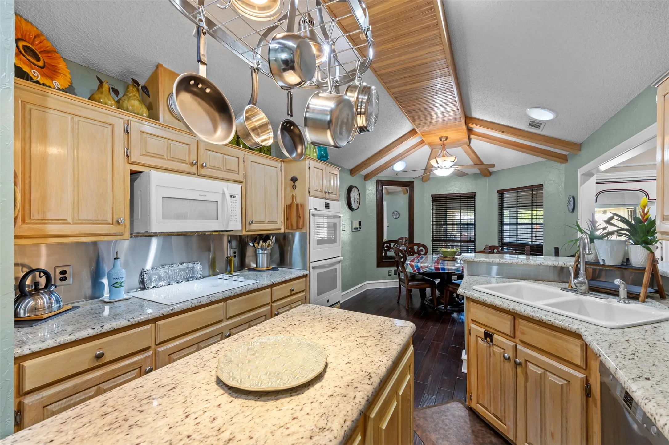 Kitchen featuring light wood cabinetry, white granite countertops, and stainless steel appliances