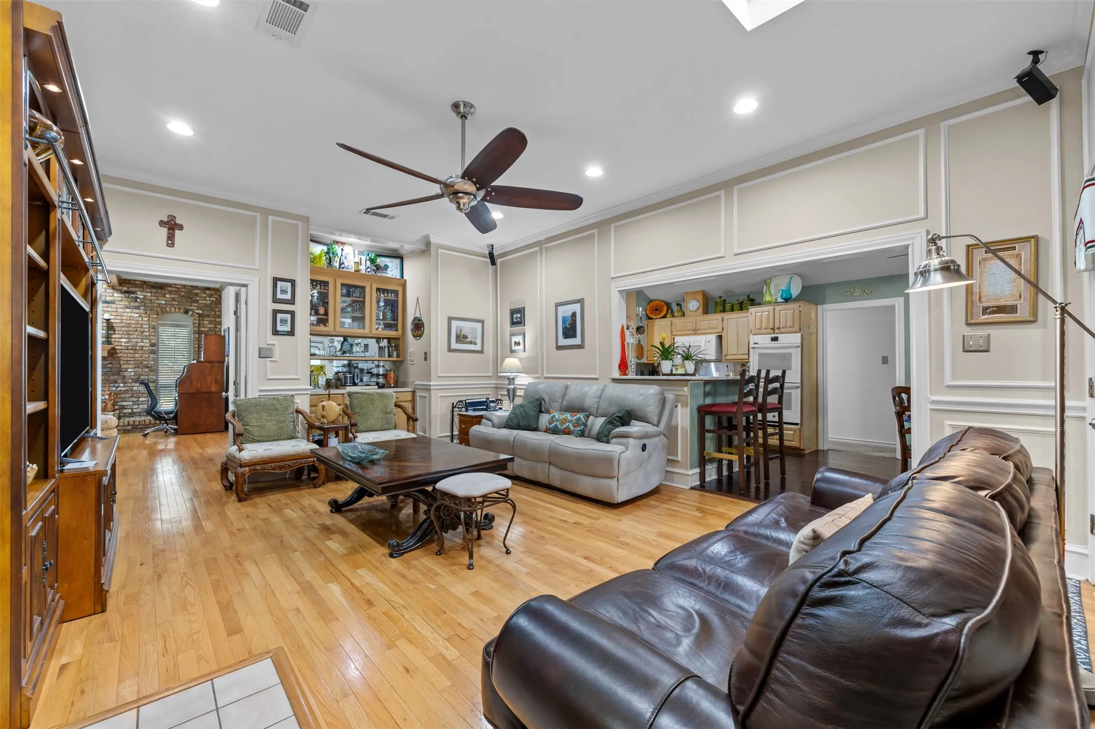 Open-concept living area featuring wood-finish flooring, recessed lighting, and a ceiling fan