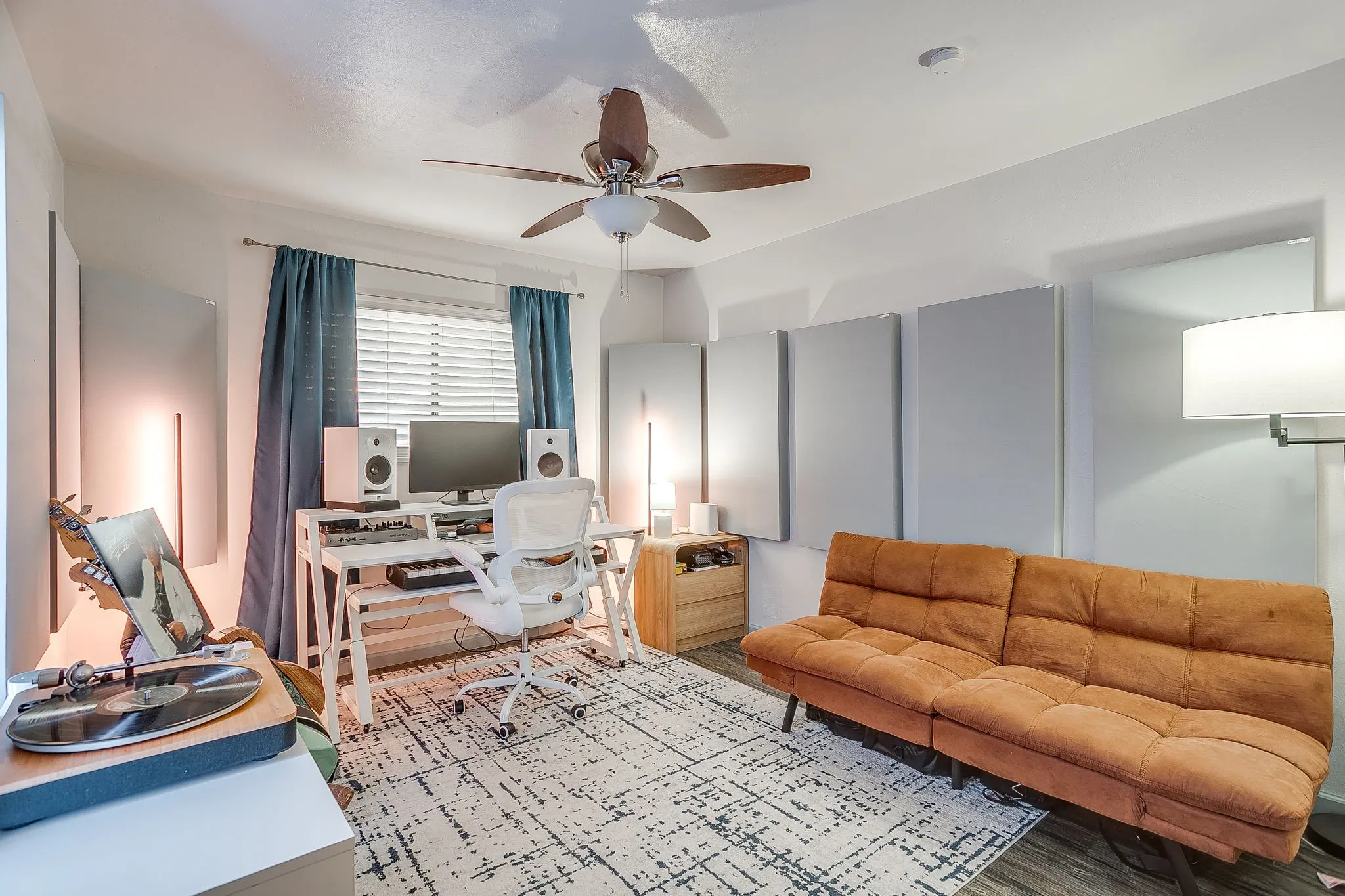 Secondary bedroom with ceiling fan, laminate flooring and reach in closet.