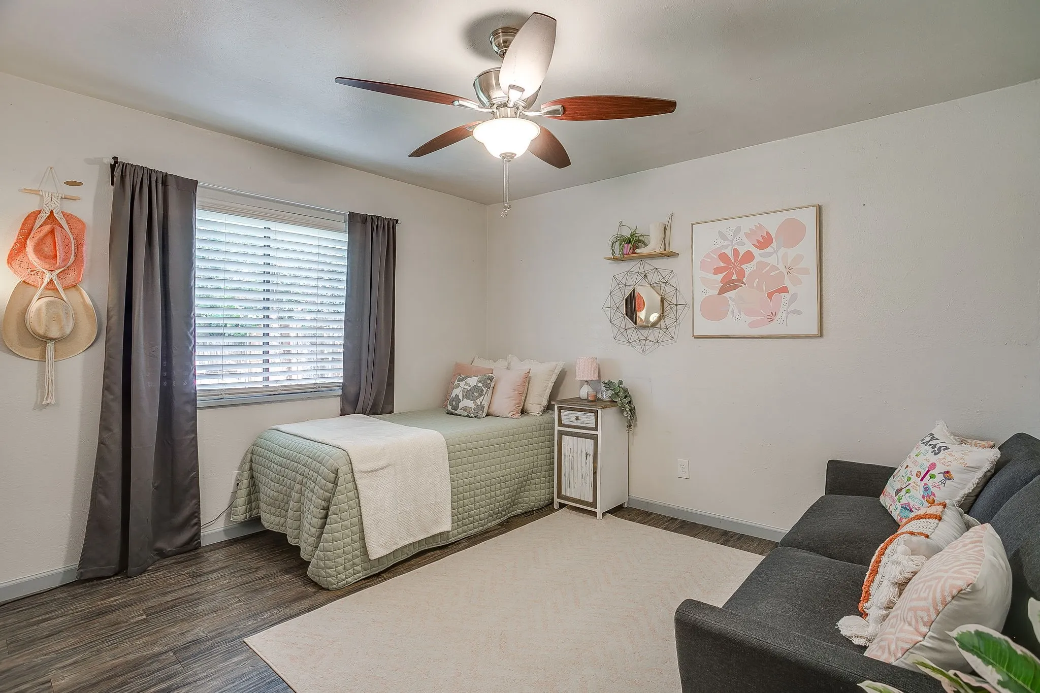 Secondary bedroom with ceiling fan, laminate flooring and reach in closet.