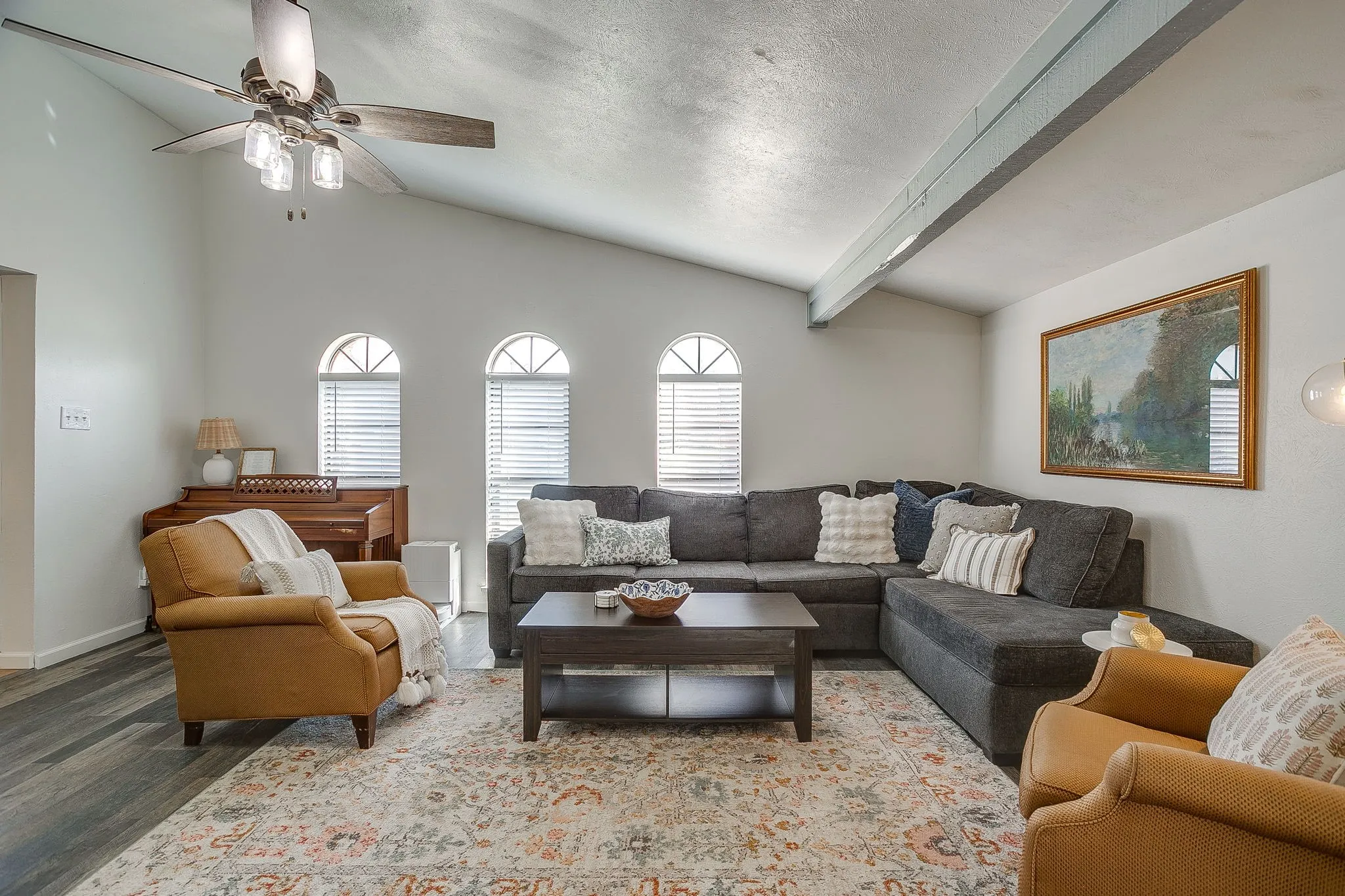 Large living room perfect for entertaining or relaxing at the end of the day with ceiling fan and vaulted ceiling.