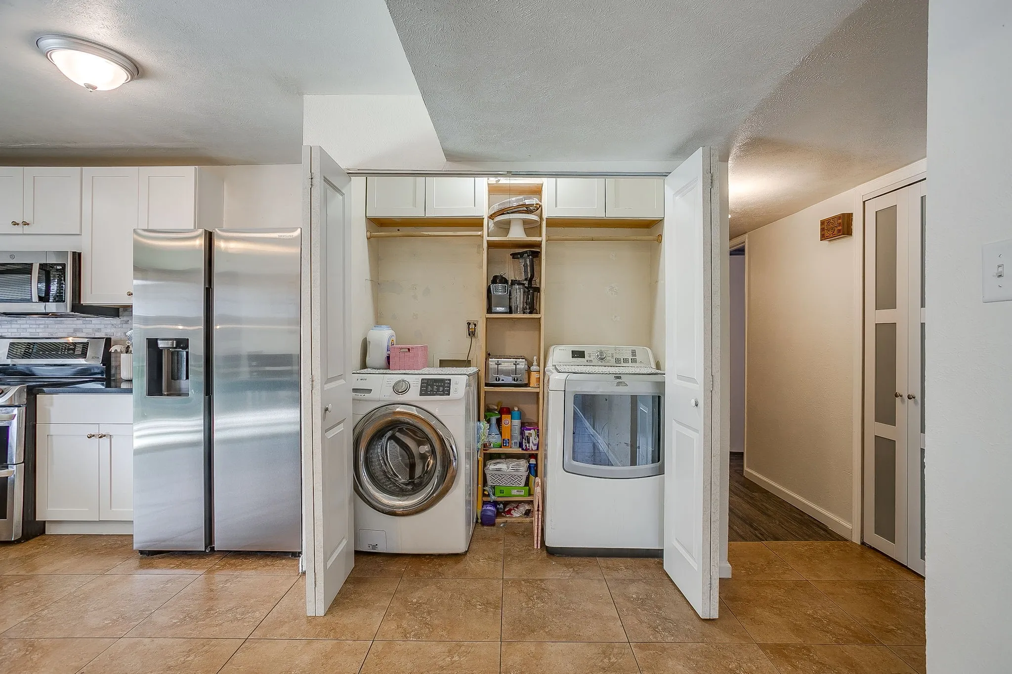 Laundry closet with additional overflow pantry or appliance storage.