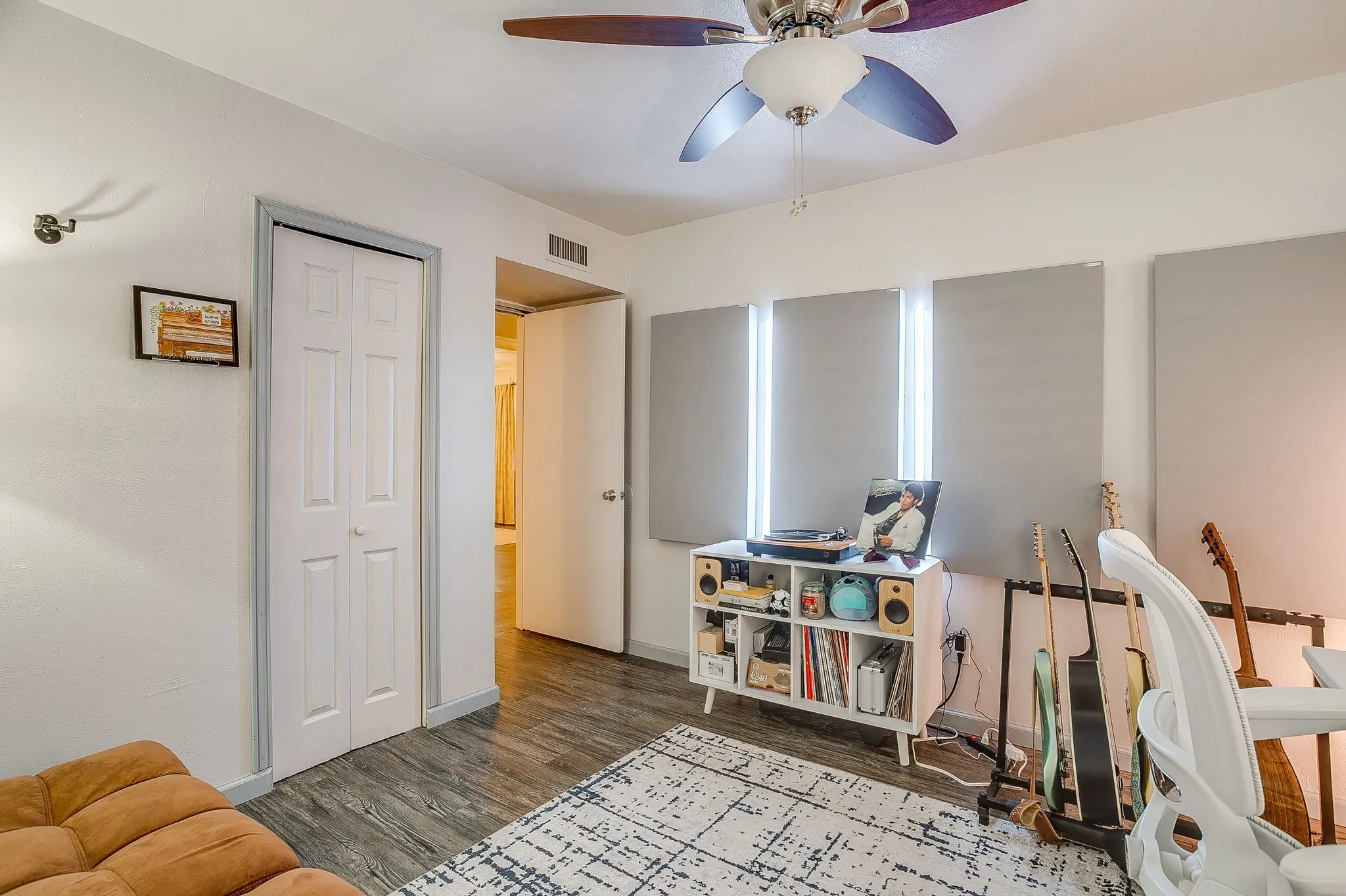 Secondary bedroom with ceiling fan, laminate flooring, reach in closet.