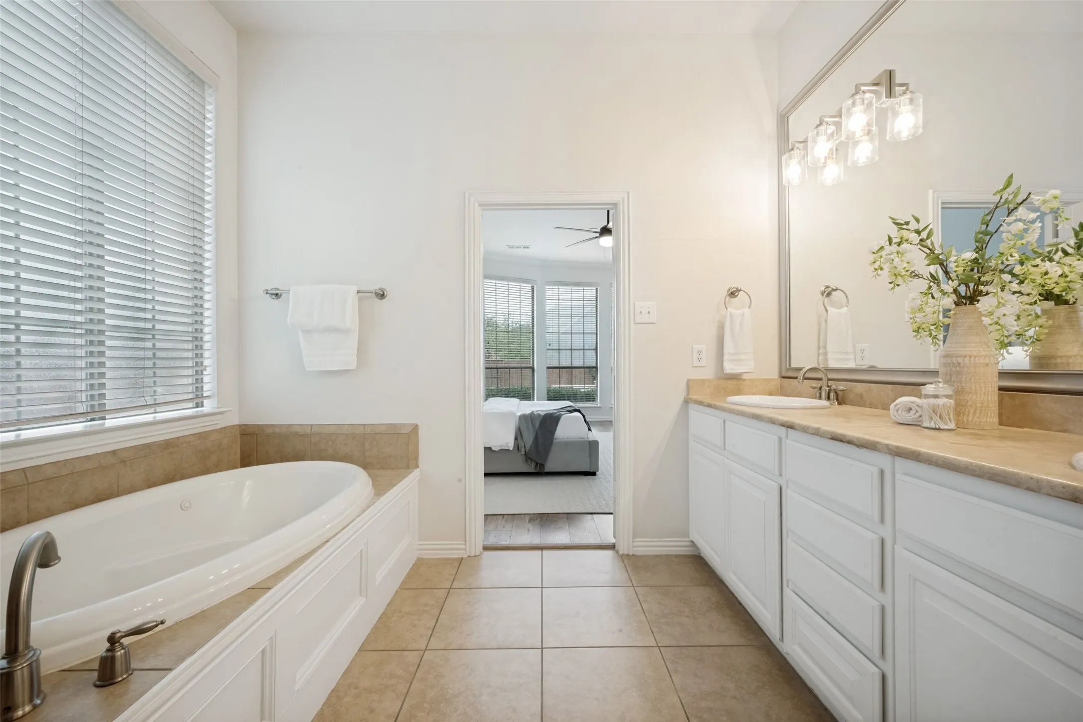 Bathroom featuring a dual vanity with a light-toned countertop, a large mirror, and a modern light fixture
