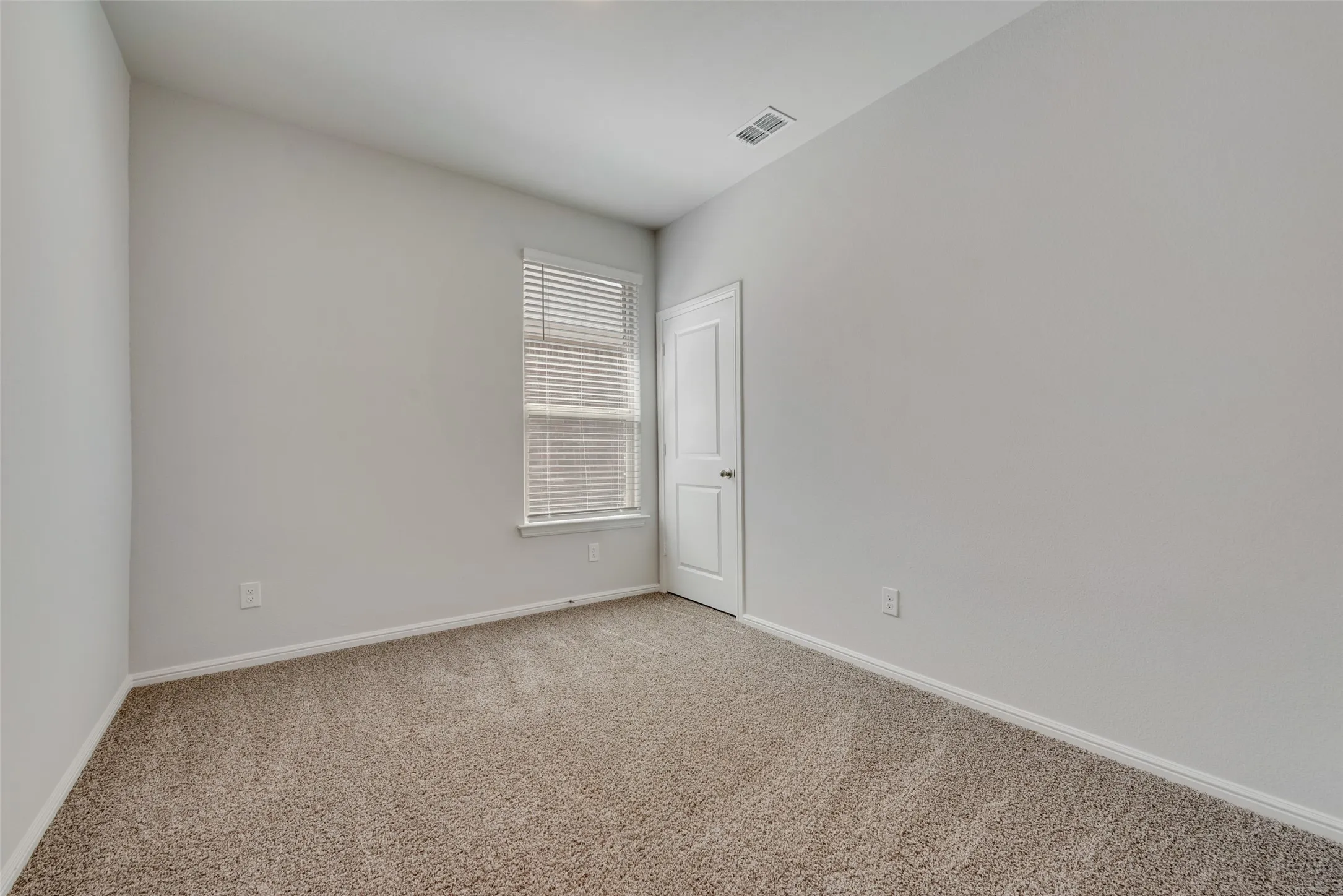 Room featuring light-colored walls and neutral carpeting