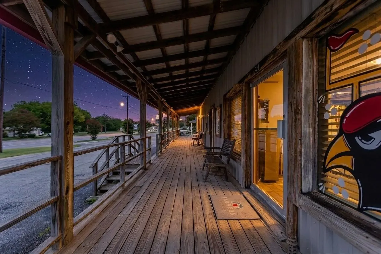 Expansive wooden covered porch with exposed timber framing and wood-finish flooring