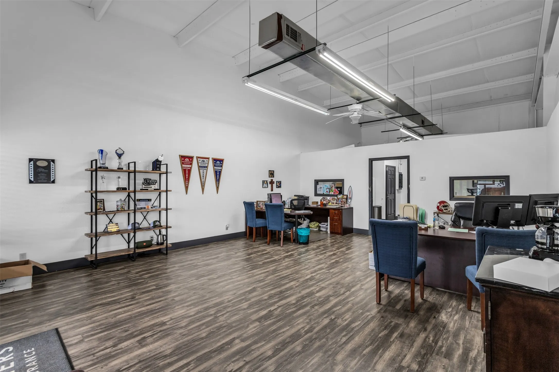 Spacious interior featuring laminate flooring, white walls, and an exposed beam ceiling