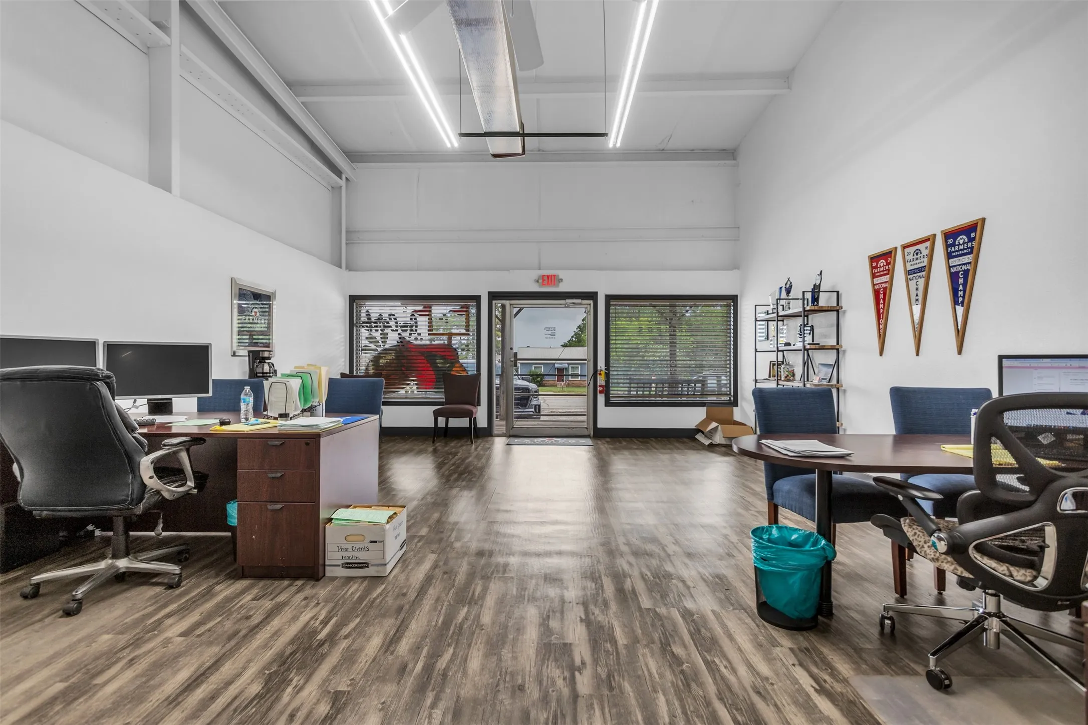 Spacious commercial interior featuring laminate flooring, high ceilings, and abundant natural light from multiple windows