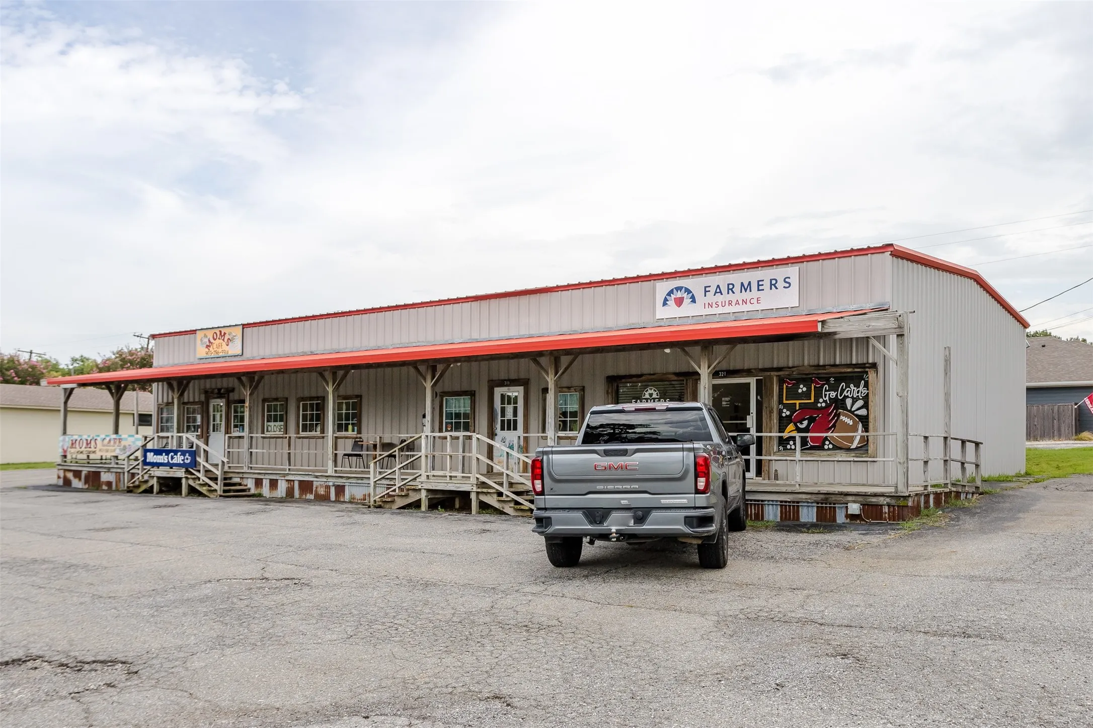 Commercial building featuring a red metal roof and corrugated metal siding facing north on Highway 120 in downtown Pottsboro