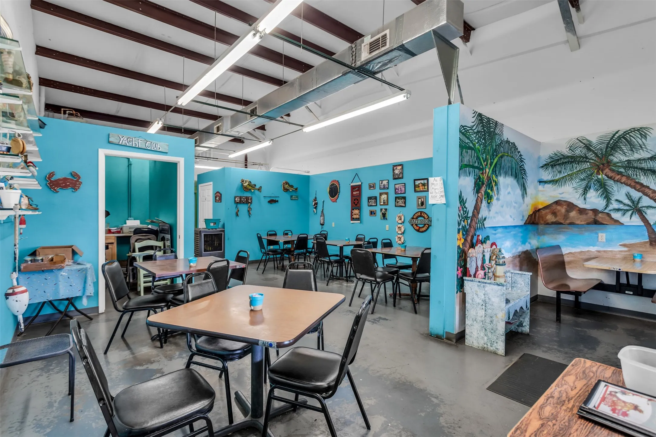 Open-concept commercial space featuring concrete flooring and a painted mural wall