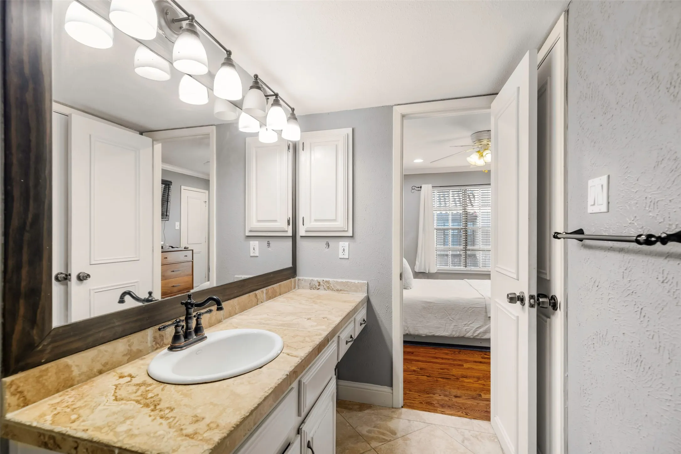 Bathroom vanity with a large framed mirror, a single oval sink, and a bronze-finish faucet