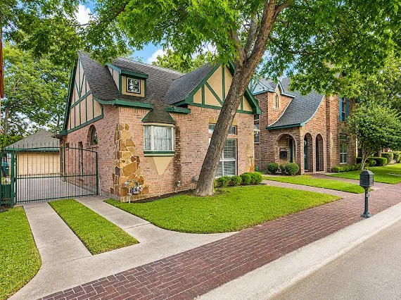 Brick facade residence featuring stone accents and a prominent bay window