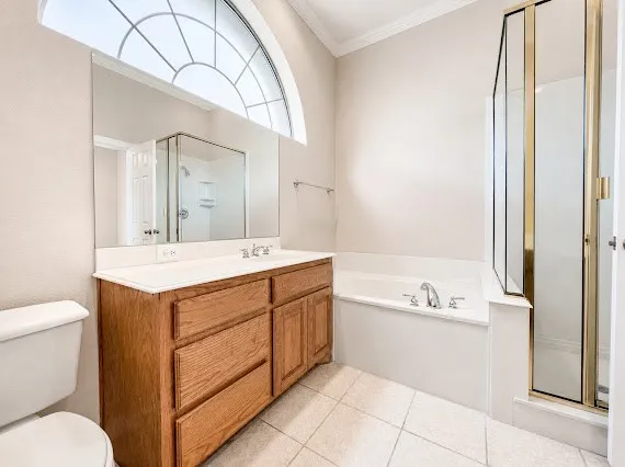 Bathroom featuring a double vanity with wood cabinetry, a large mirror, and an arched transom window