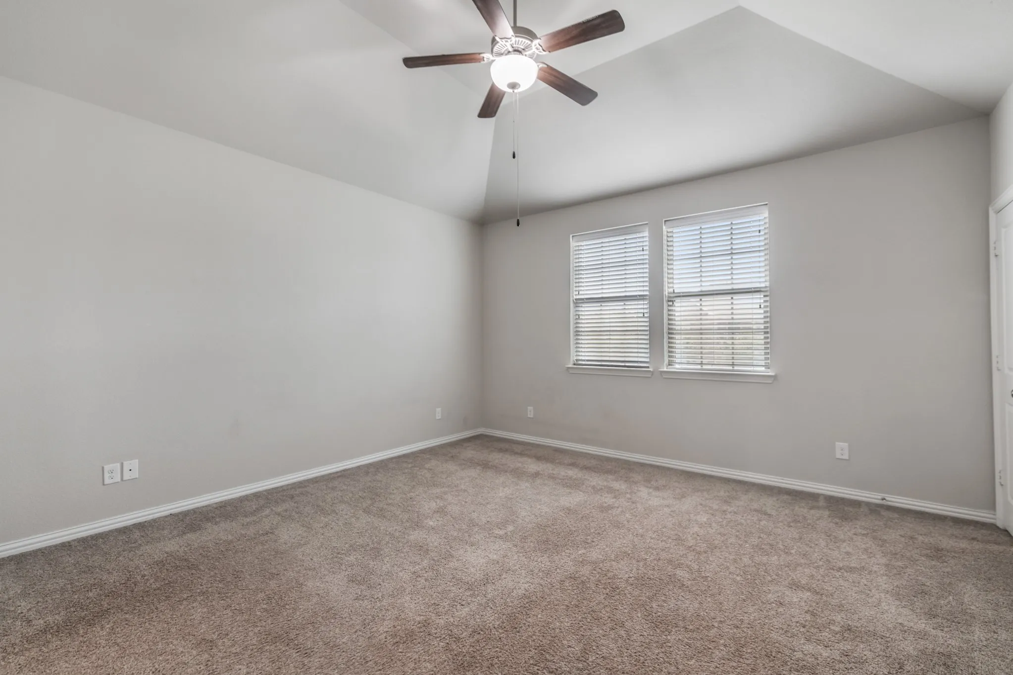 Vaulted ceiling featuring a ceiling fan with light fixture