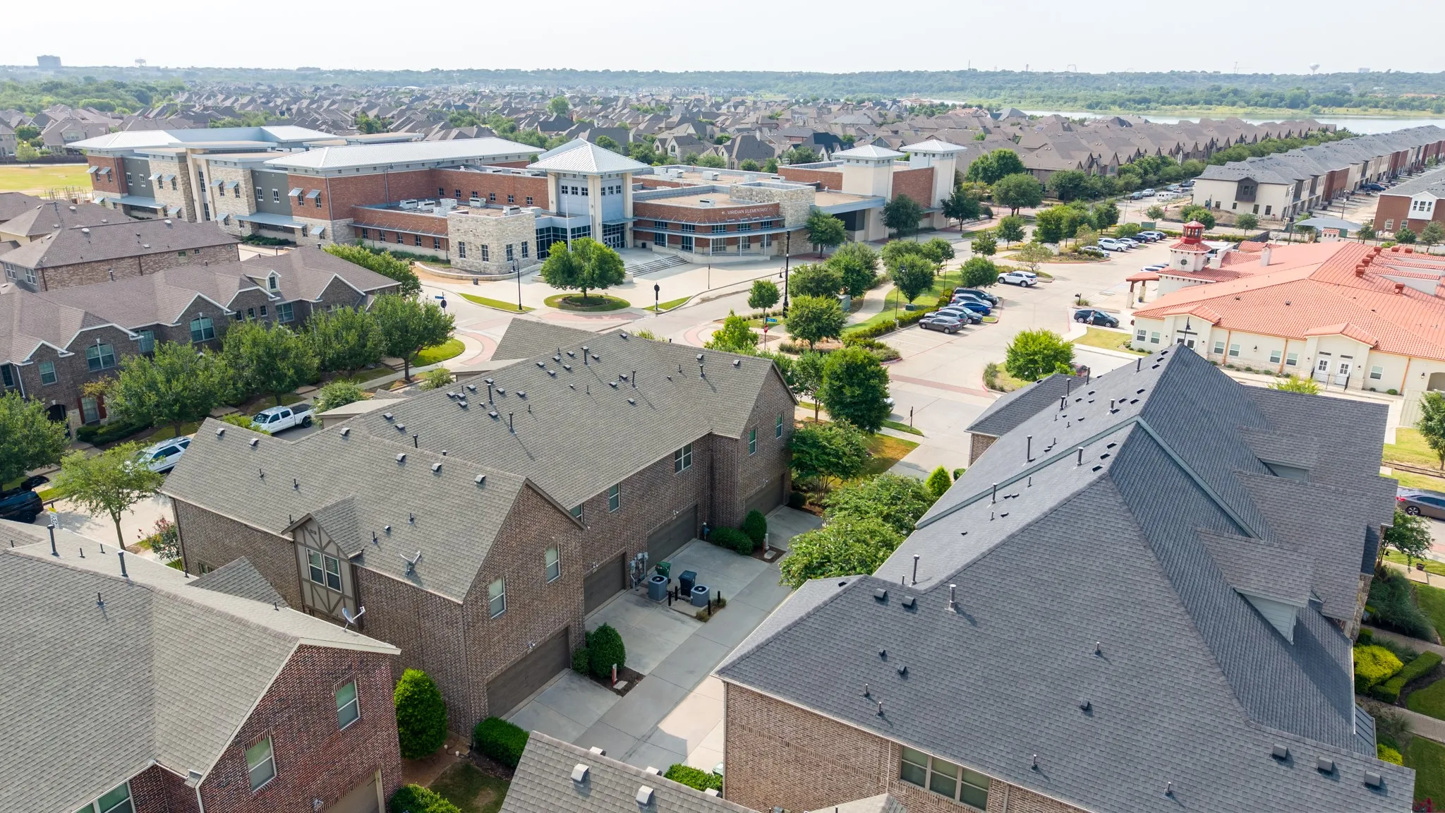 Aerial view showcasing this contemporary brick residence with distinctive pitched rooflines and multiple geometric forms