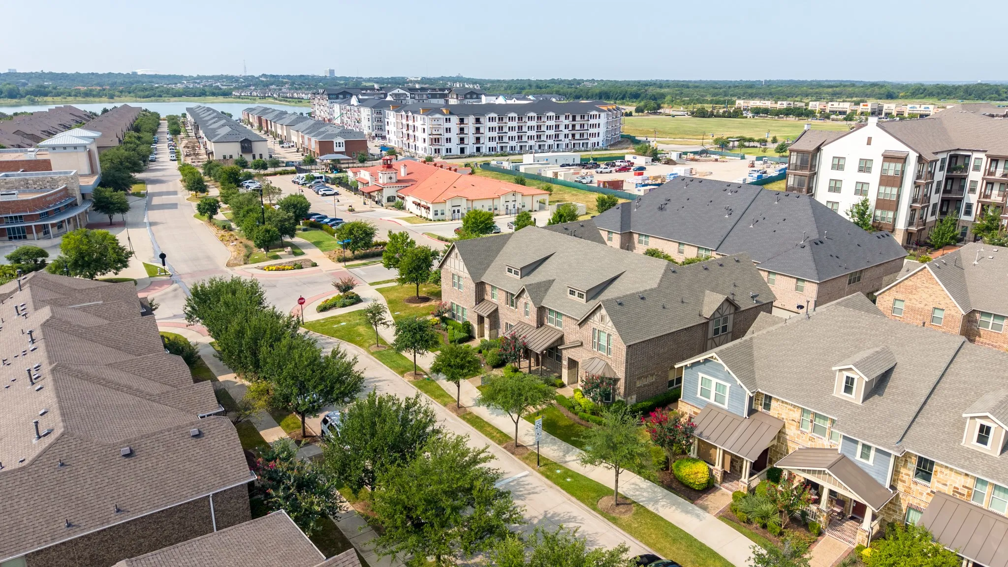 Aerial community overview showcasing a street lined with residential properties featuring varied architectural styles and mature landscaping