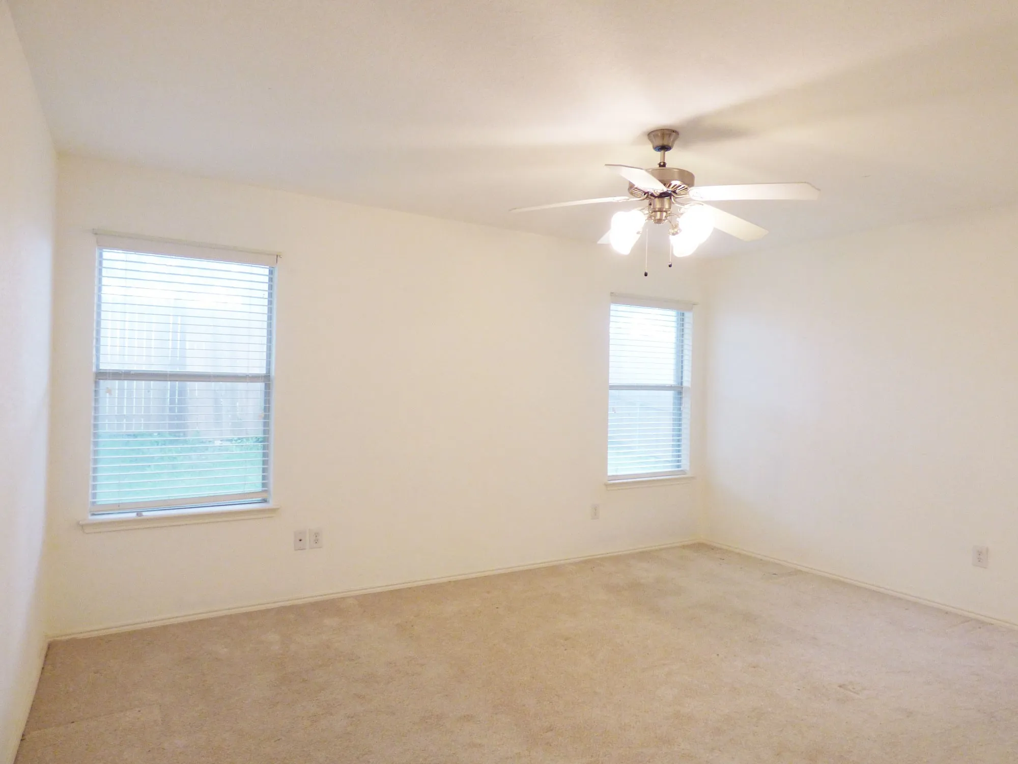 Neutral tone wall paint with two windows featuring blinds