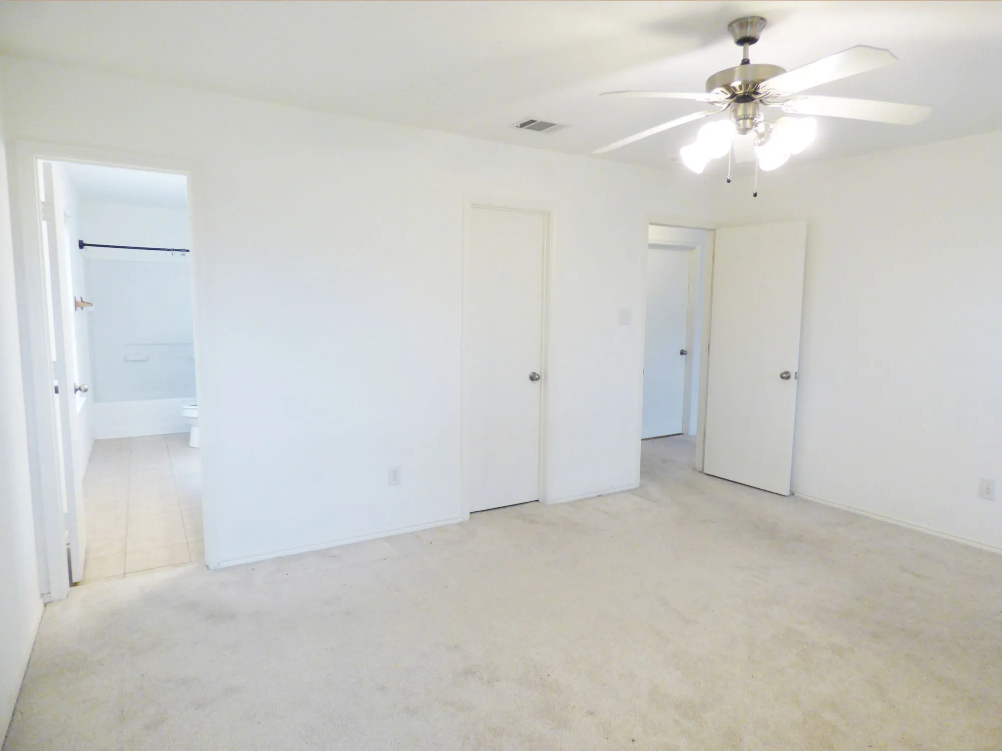 Carpeted interior room with a ceiling fan light fixture