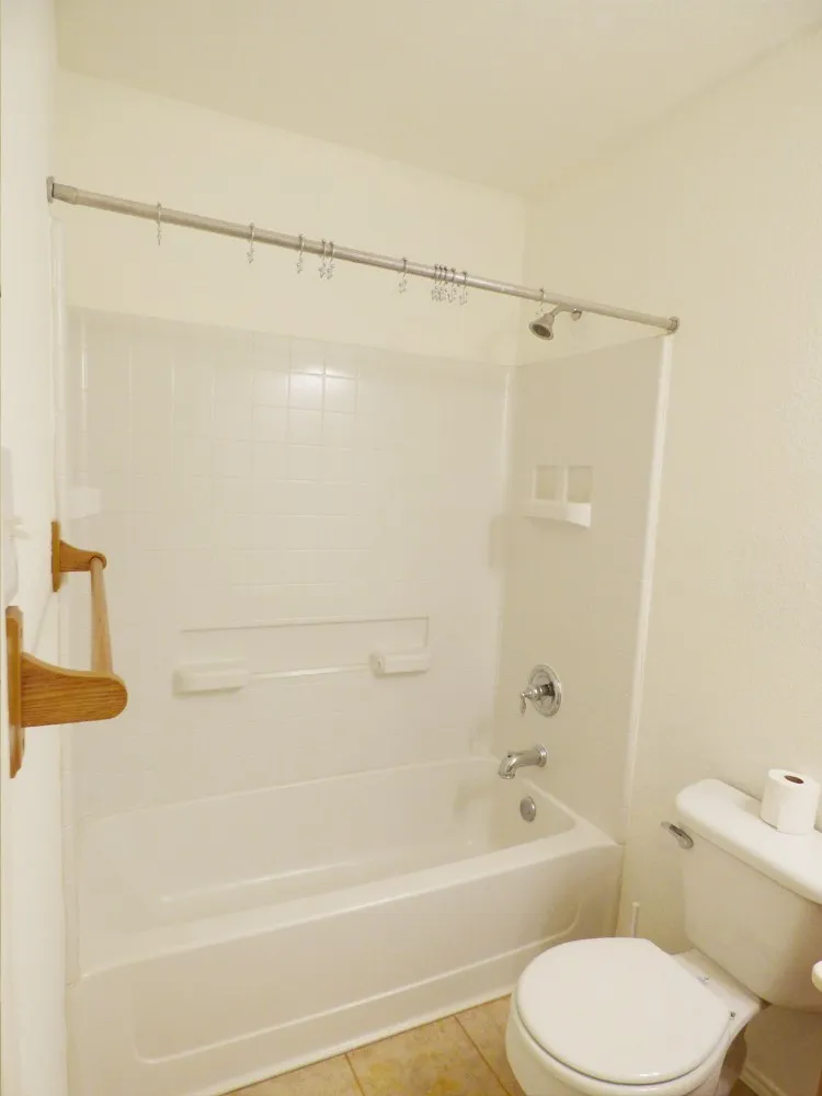Full bathtub with an integrated shower, featuring a chrome showerhead and faucet