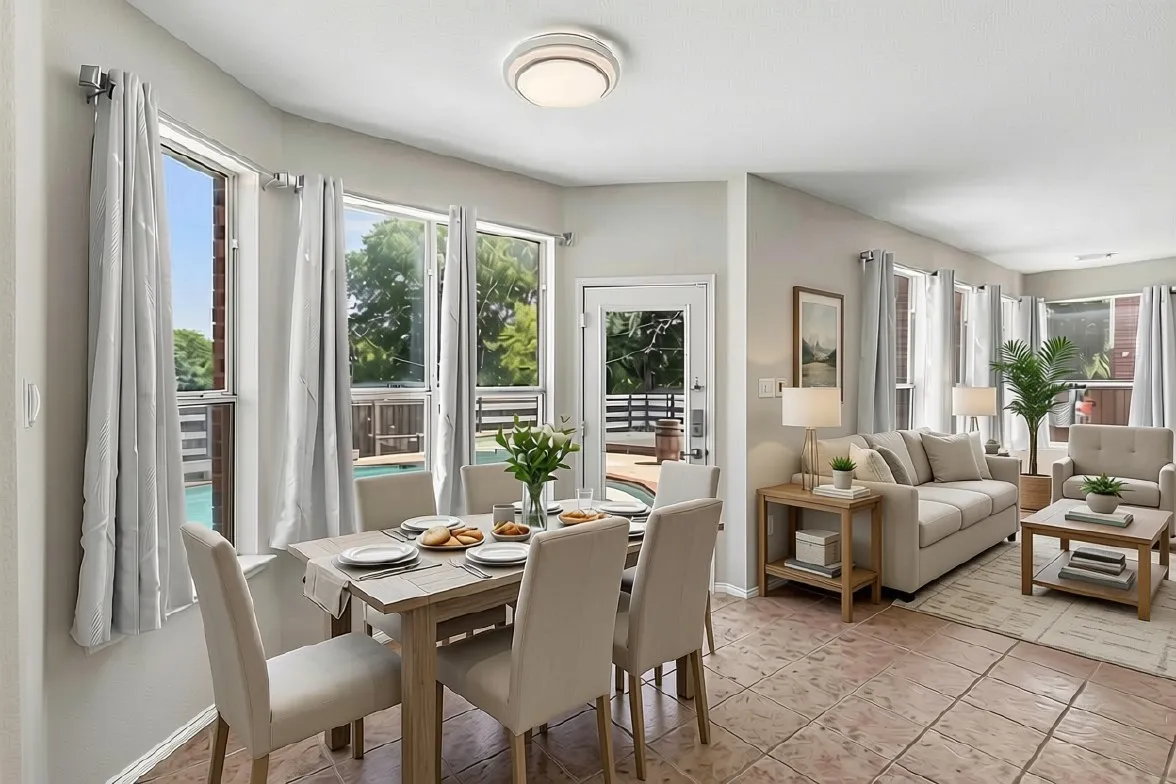 Open-concept dining and living areas bathed in natural light through multiple glass doors and windows with transom details