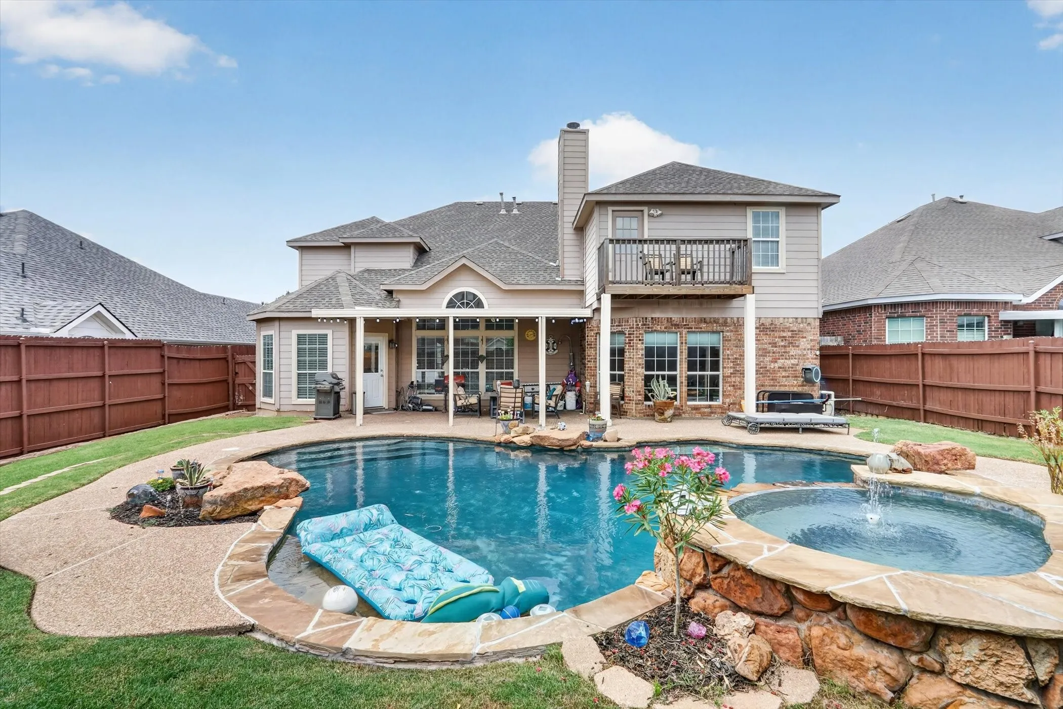 Backyard featuring an in-ground swimming pool and an integrated spa with waterfall